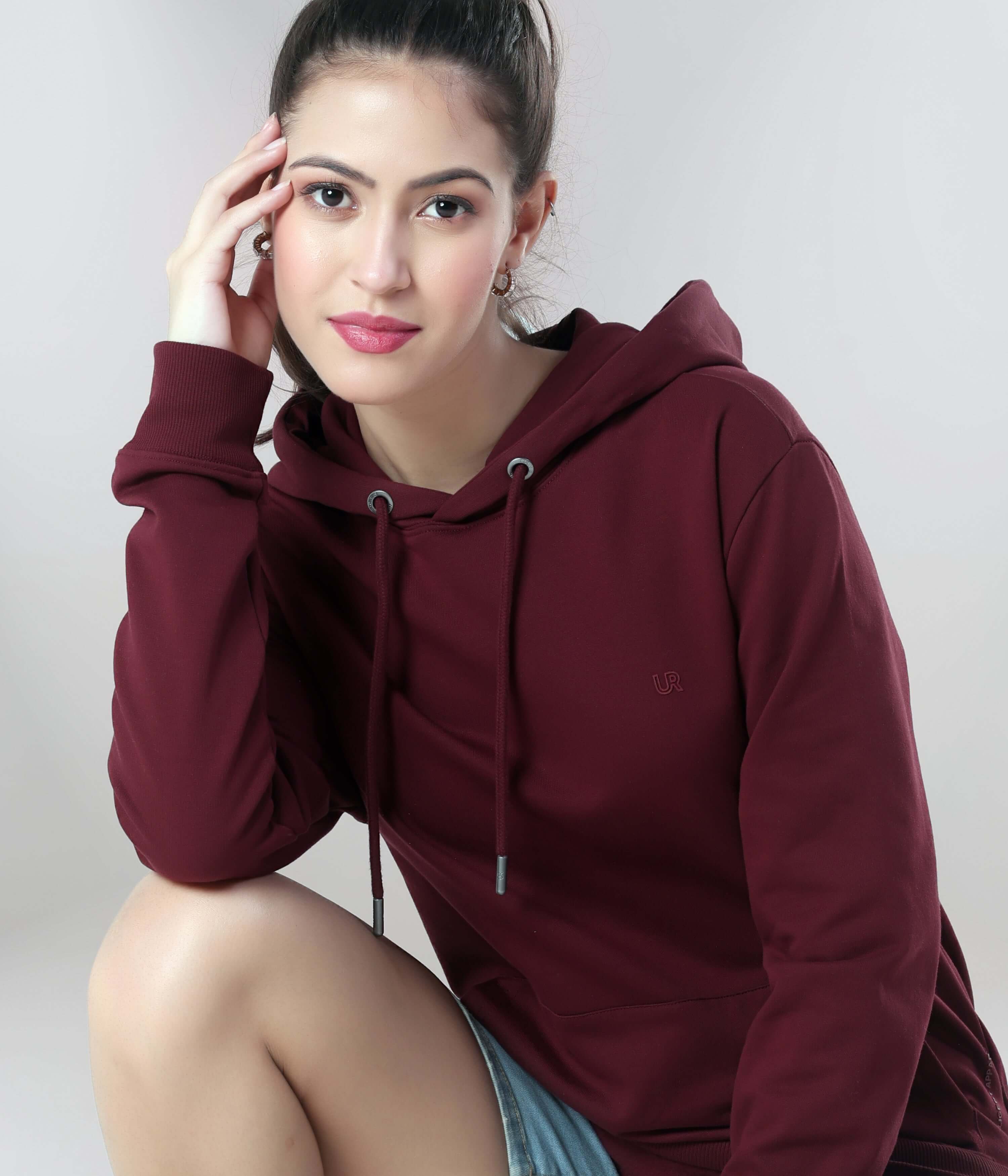 Elegant woman in a burgundy women's hoodie, showcasing anti-stain, waterproof features of intelligent apparel. Best in India.