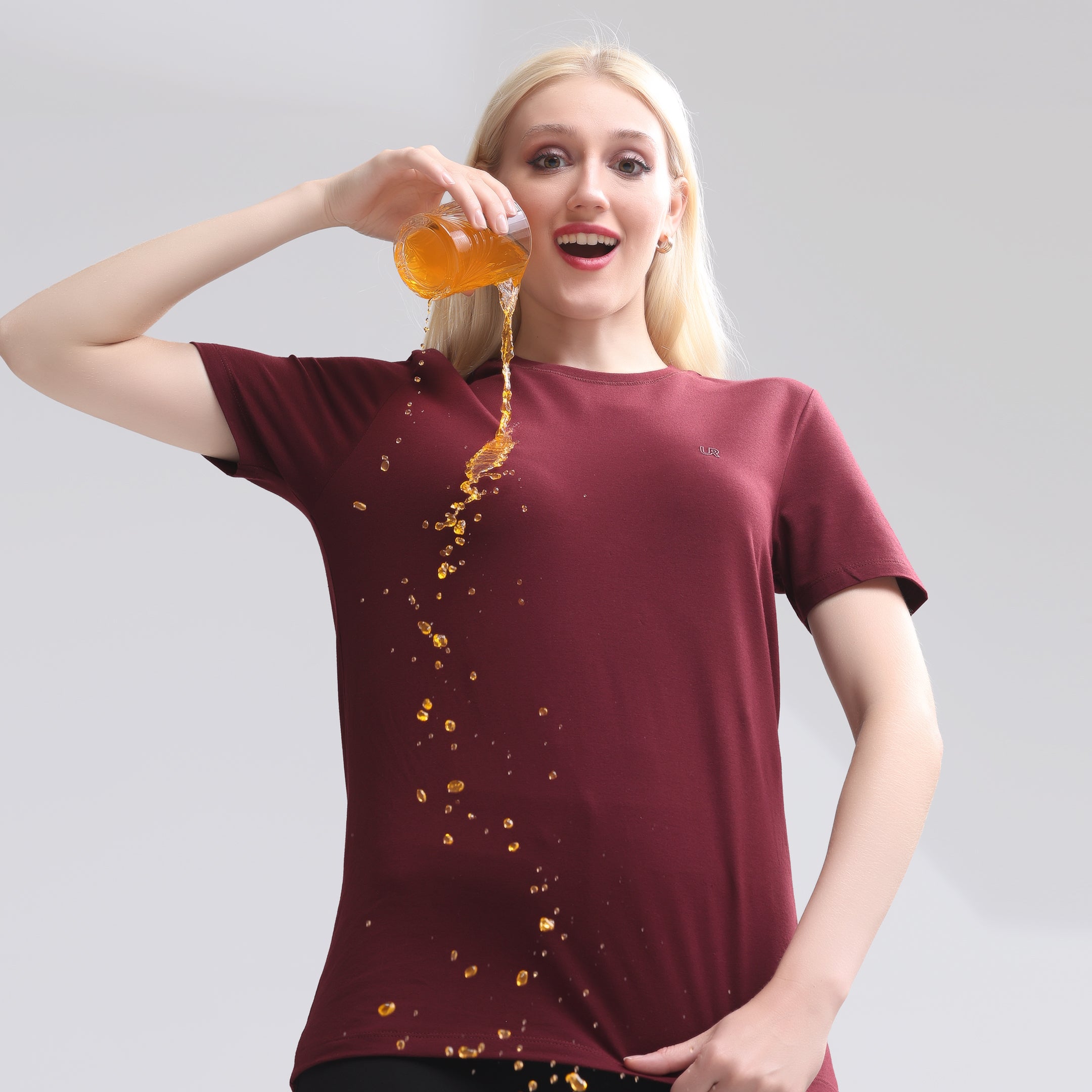 Woman in a burgundy t-shirt pouring drink, showcasing Turms intelligent apparel's innovative technology in menswear.
