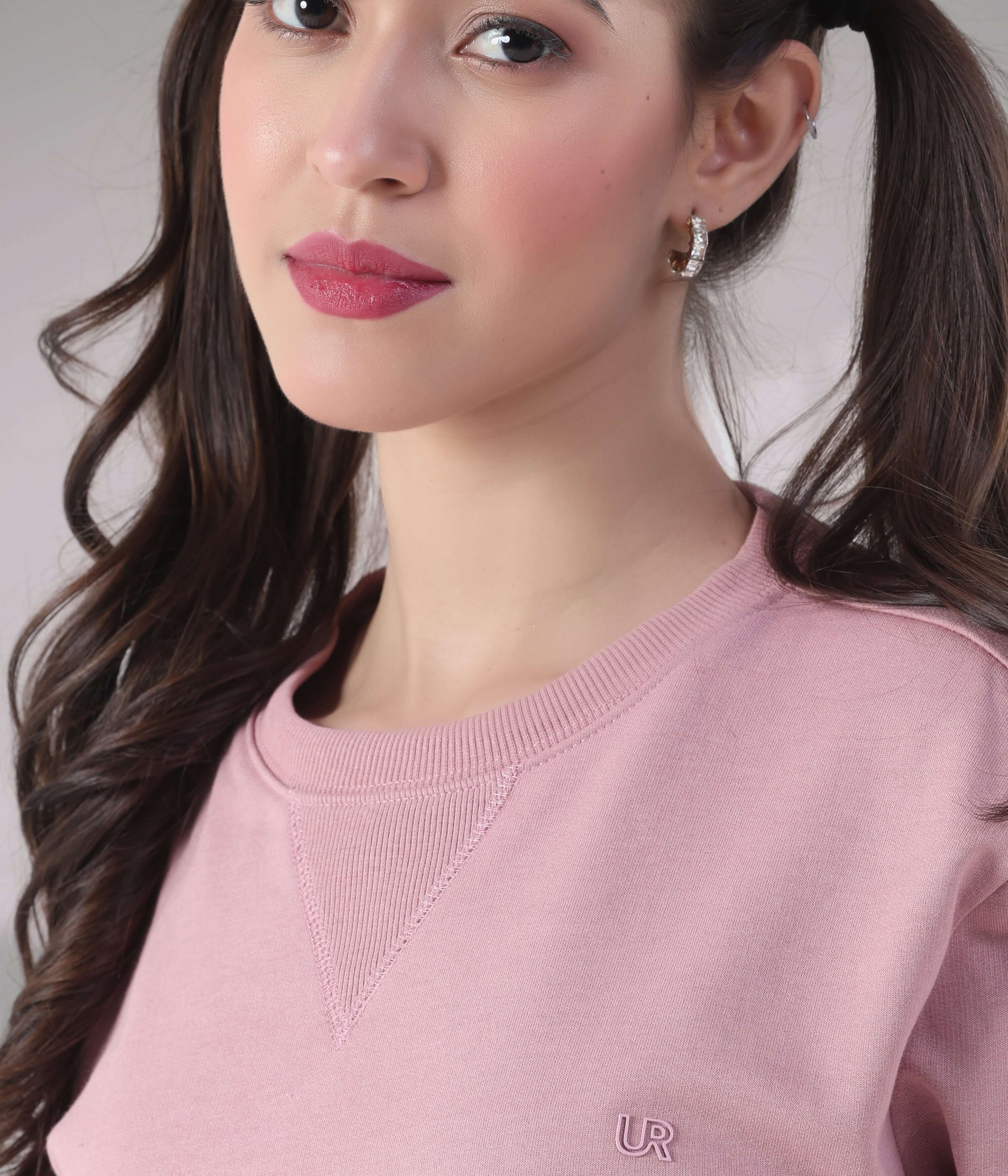 Close-up of a model wearing the pink Turms Intelligent Sweatshirt with a signature V-notch neckline and a stylish, comfortable design.