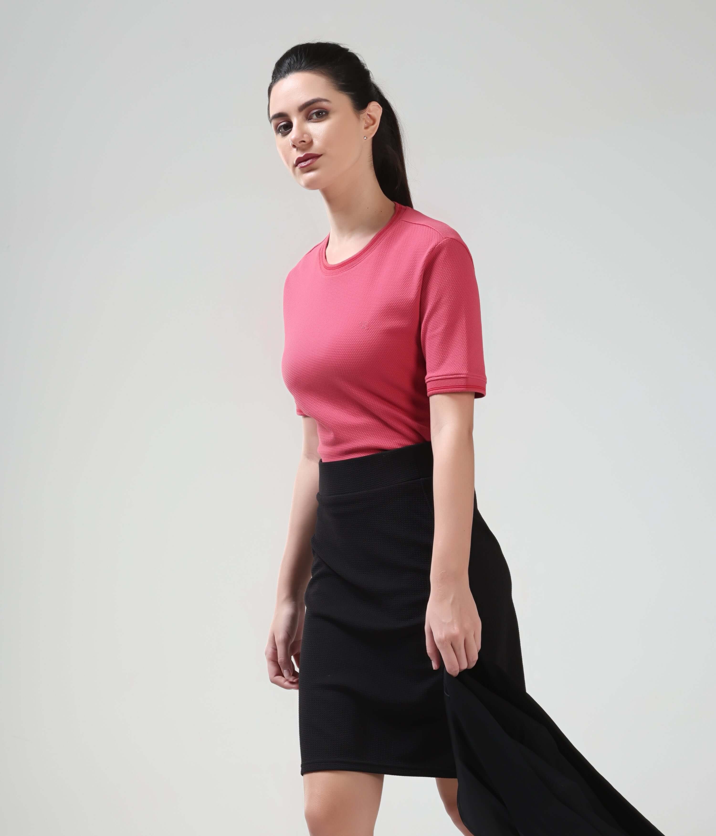 Woman wearing Regal Pink Turms T-Shirt with COOLTECH, showcasing anti-odour honeycomb fabric for a tailored fit and new colour intelligent apparel.
