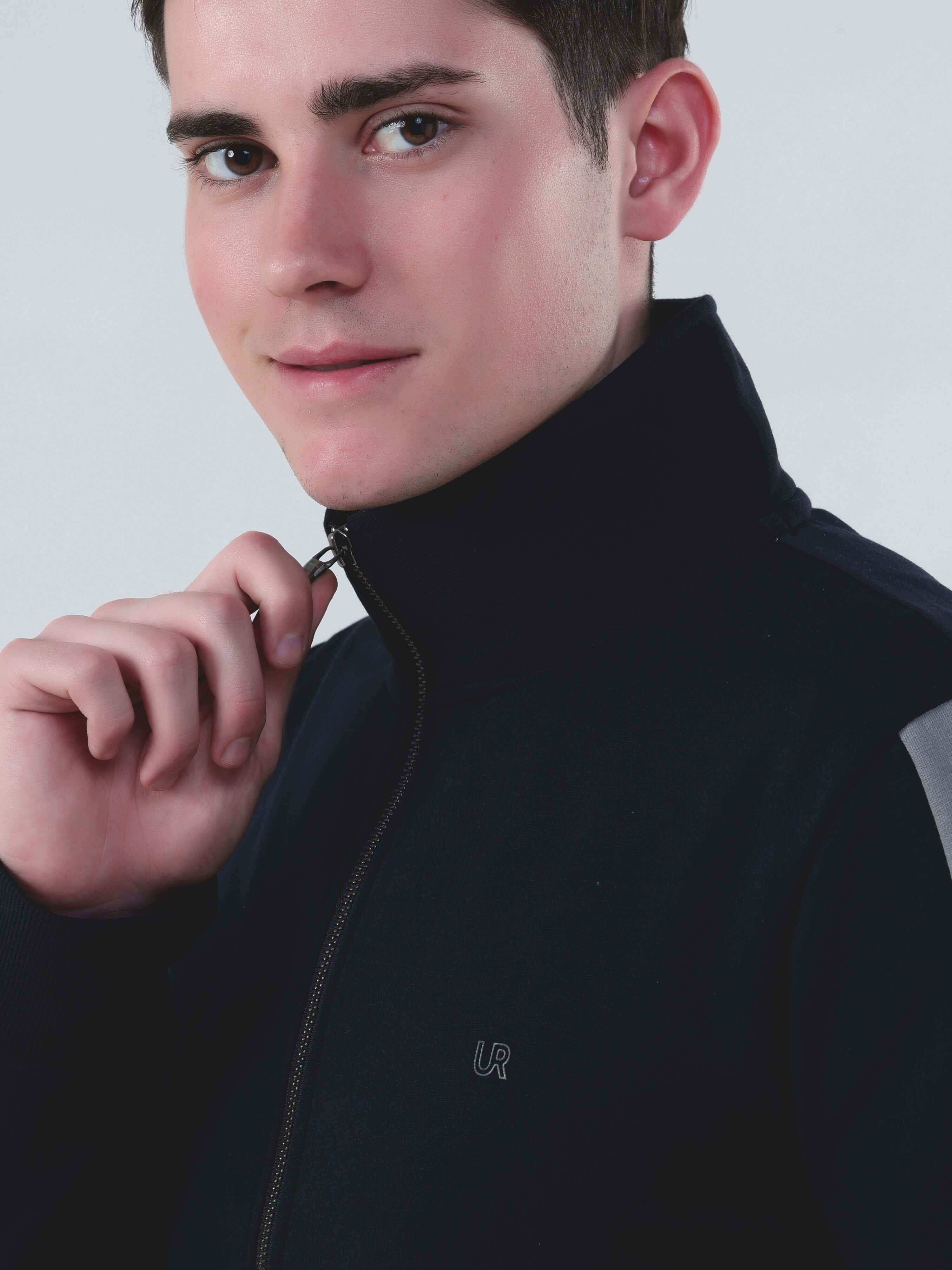 Model wearing a stylish black zip-up jacket, promoting Turms Intelligent Cord Set for men and women.