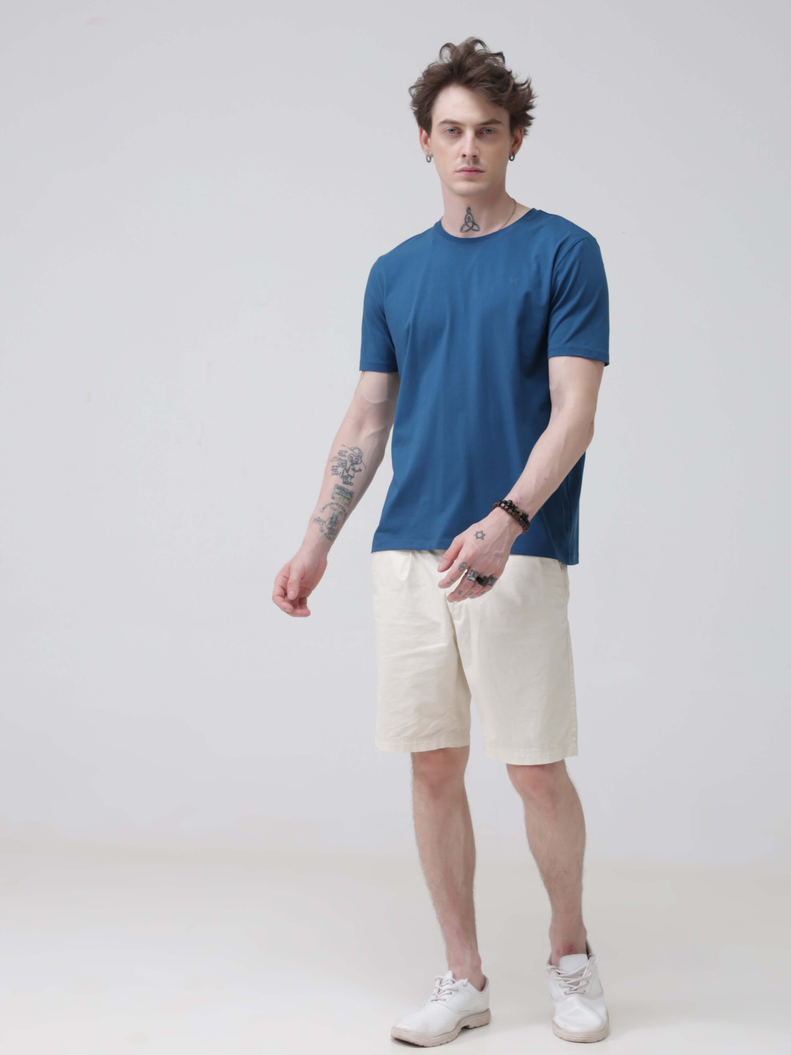 Man wearing Sea Blue round neck tshirt and white shorts stylish tshirts for men. Trending mens tshirts online, tailored fit branded tshirts for men.