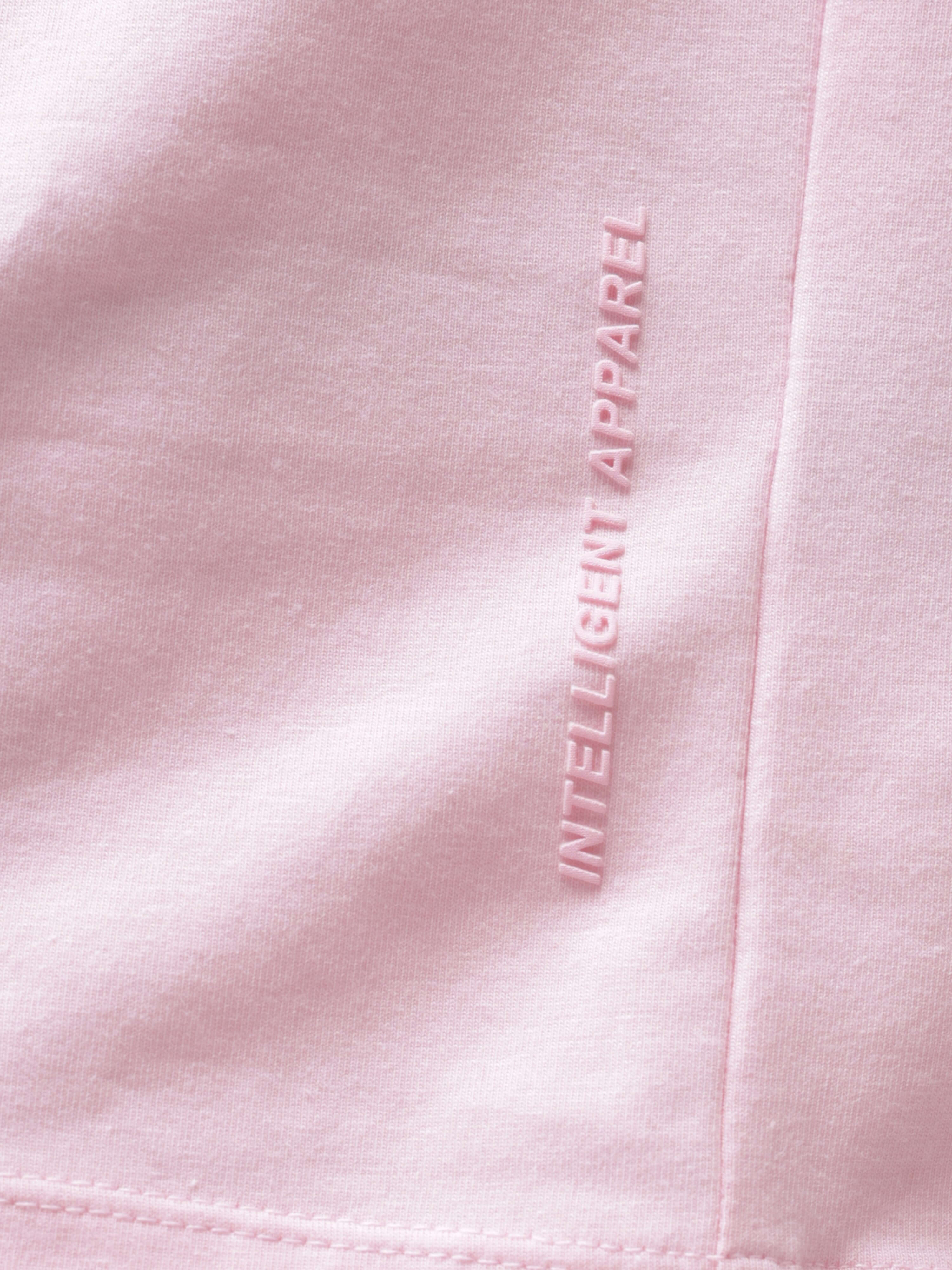 Close-up of pink Turms T-shirt with "Intelligent Apparel" text highlighting anti-stain, anti-odor, and stretchable fabric features.