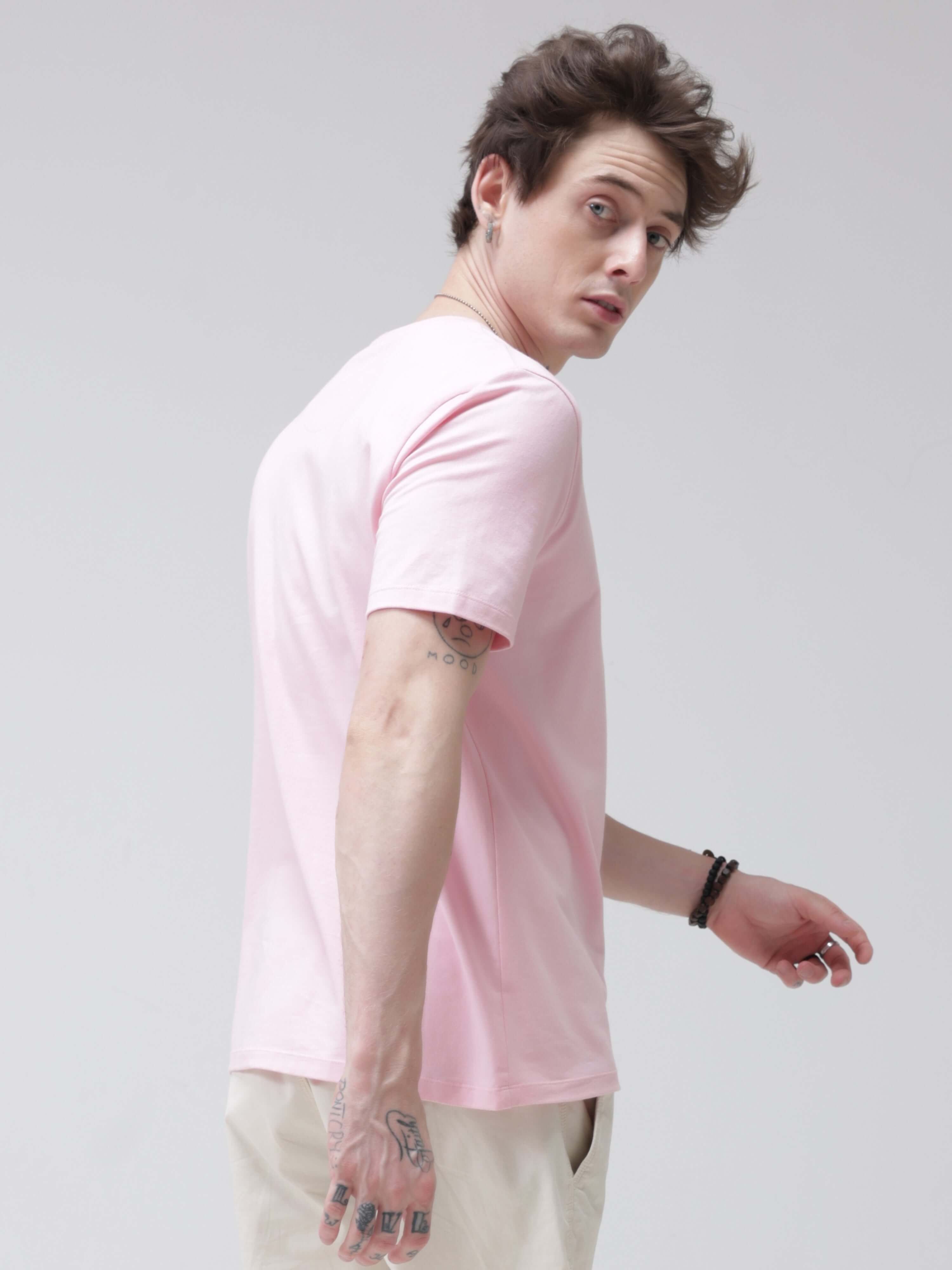 Man wearing a pink round-neck anti-stain and anti-odour Turms T-shirt made of stretchable fabric, perfect for intelligent apparel.
