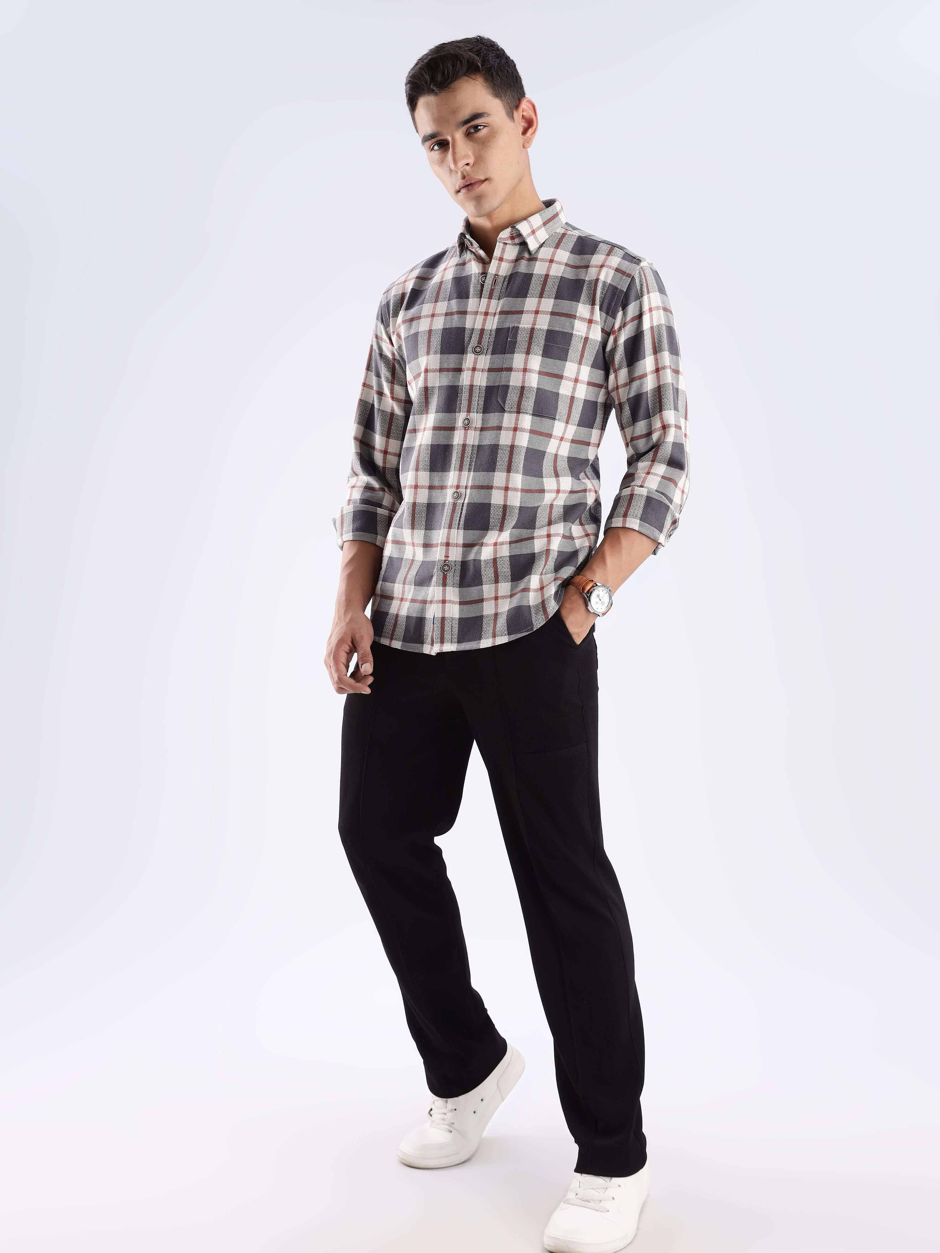 Man wearing a grey checked recycled cotton shirt with black pants, showcasing sustainable fashion and style.