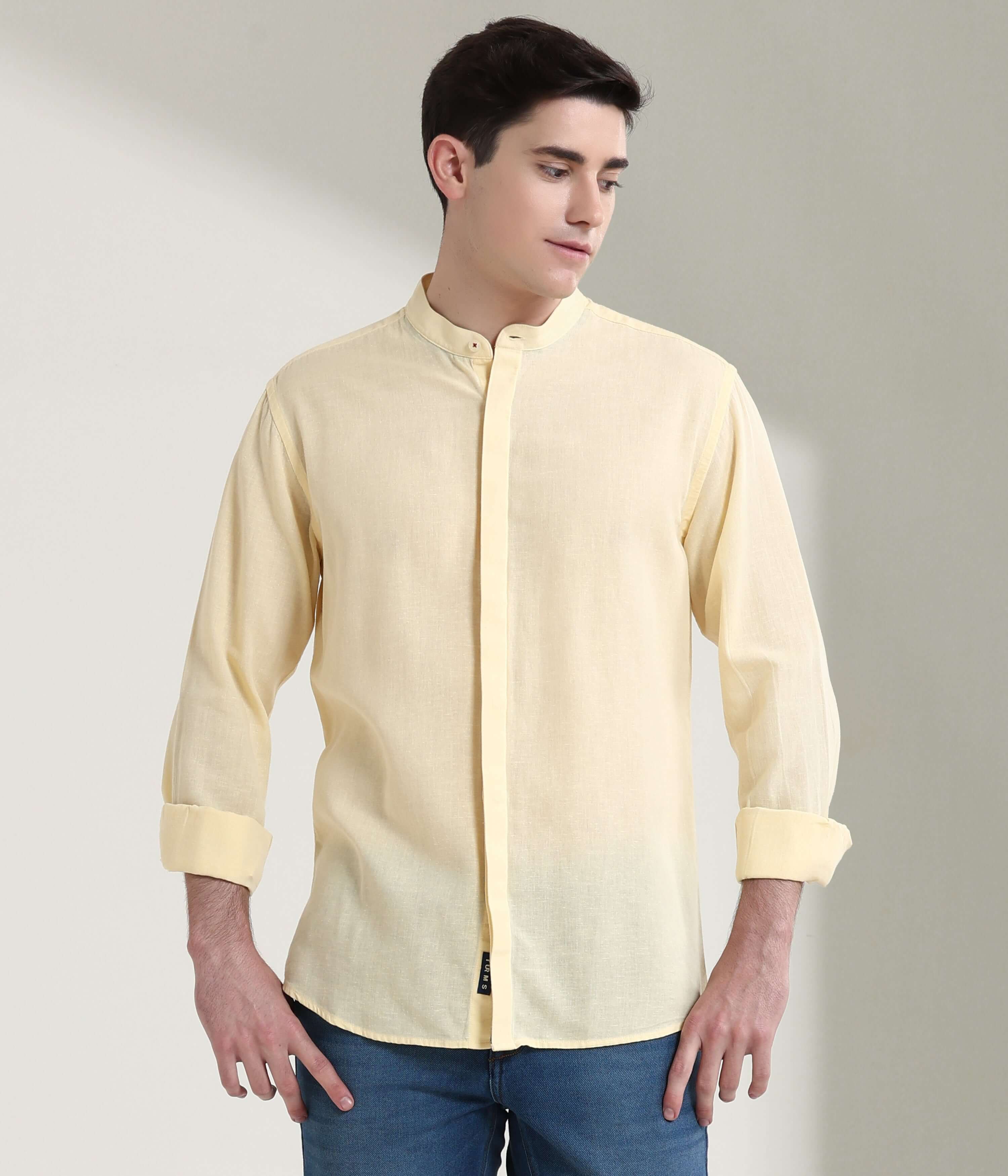 Man wearing pastel yellow linen shirt with mandarin collar, showcasing Turms intelligent apparel's anti-stain, anti-odour features.