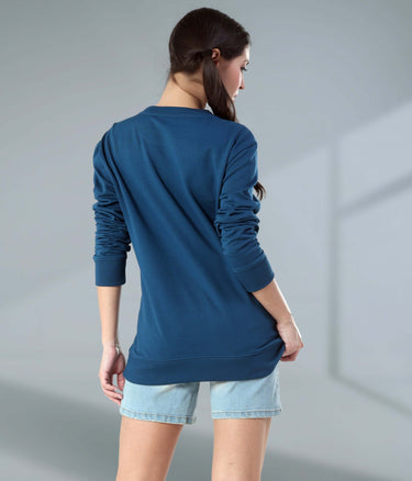 Woman in blue Turms Intelligent Sweatshirt, showcasing premium fabric and V-notch neckline, perfect for travel wear.