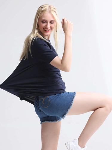 Woman wearing a blue round-neck t-shirt and denim shorts, showcasing the stretch and comfort of the premium cotton and spandex blend fabric.