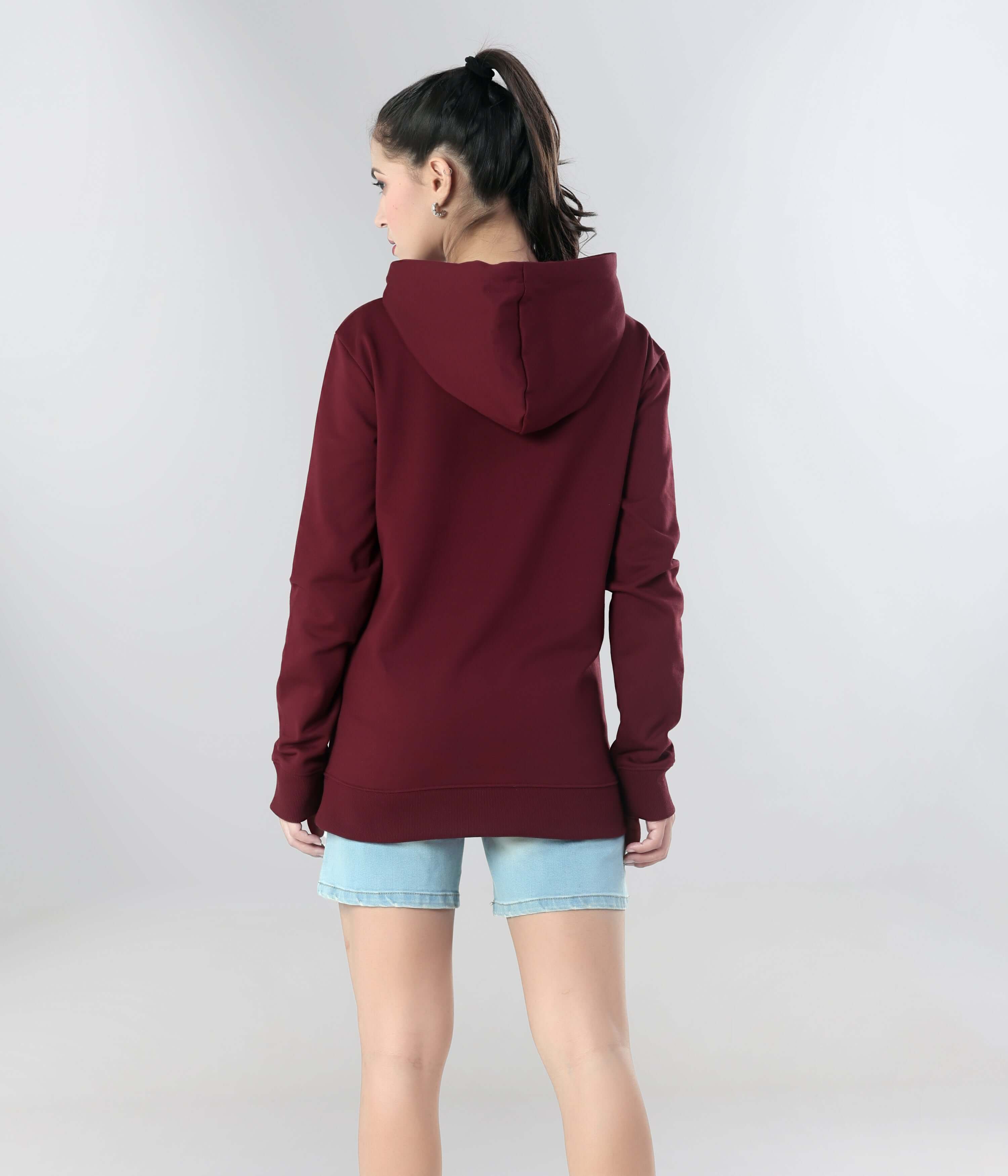 Back view of a woman in a maroon Turms Intelligent Hooded Sweatshirt, showcasing comfort and style for travel wear.