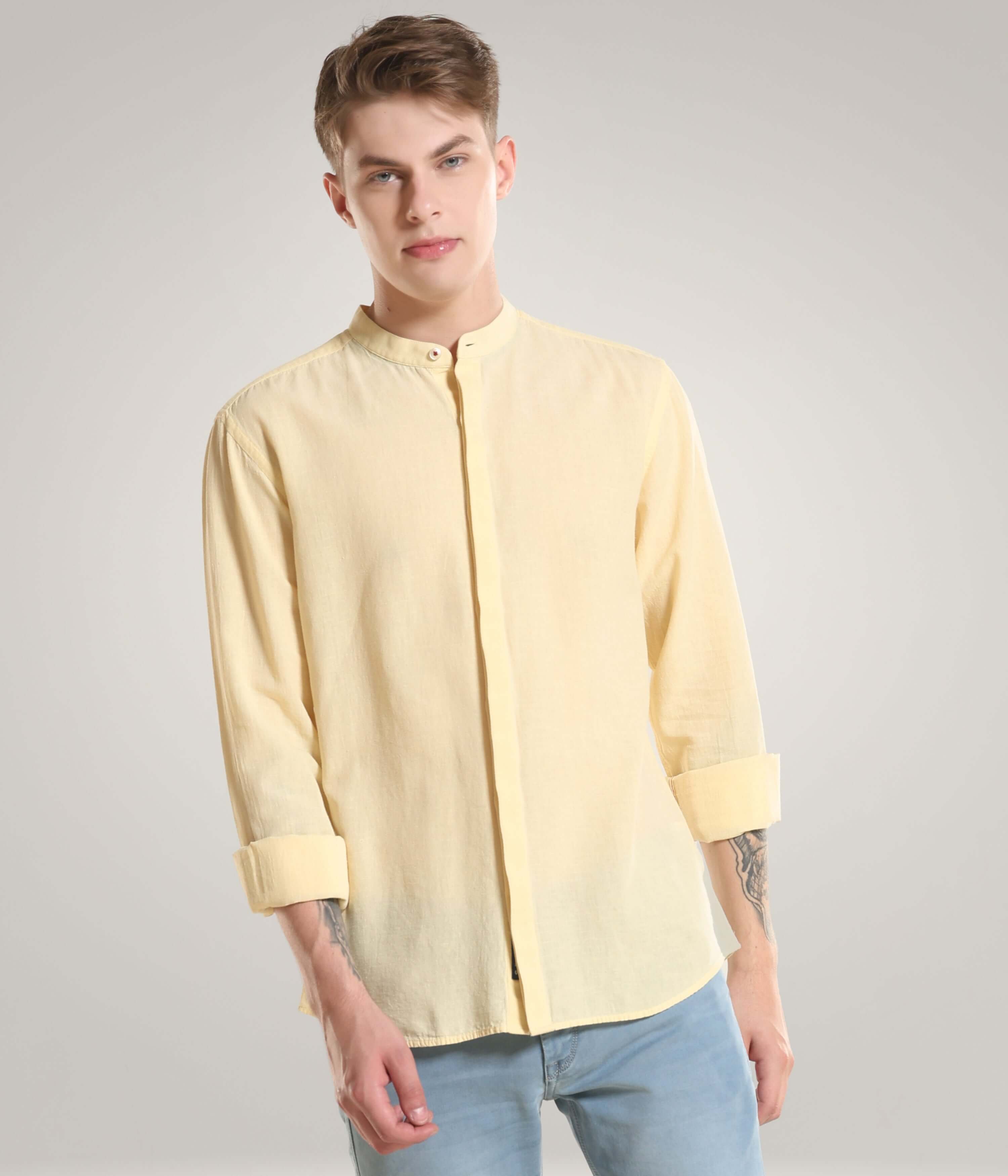 A model wearing a pastel yellow cotton/linen Turms shirt with mandarin collar, showcasing premium intelligent apparel with Cooltech, antistain, and anti-odour features