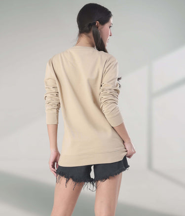 Woman wearing a beige Turms Intelligent Sweatshirt, showcasing stylish design and comfortable fit, perfect for travel wear.