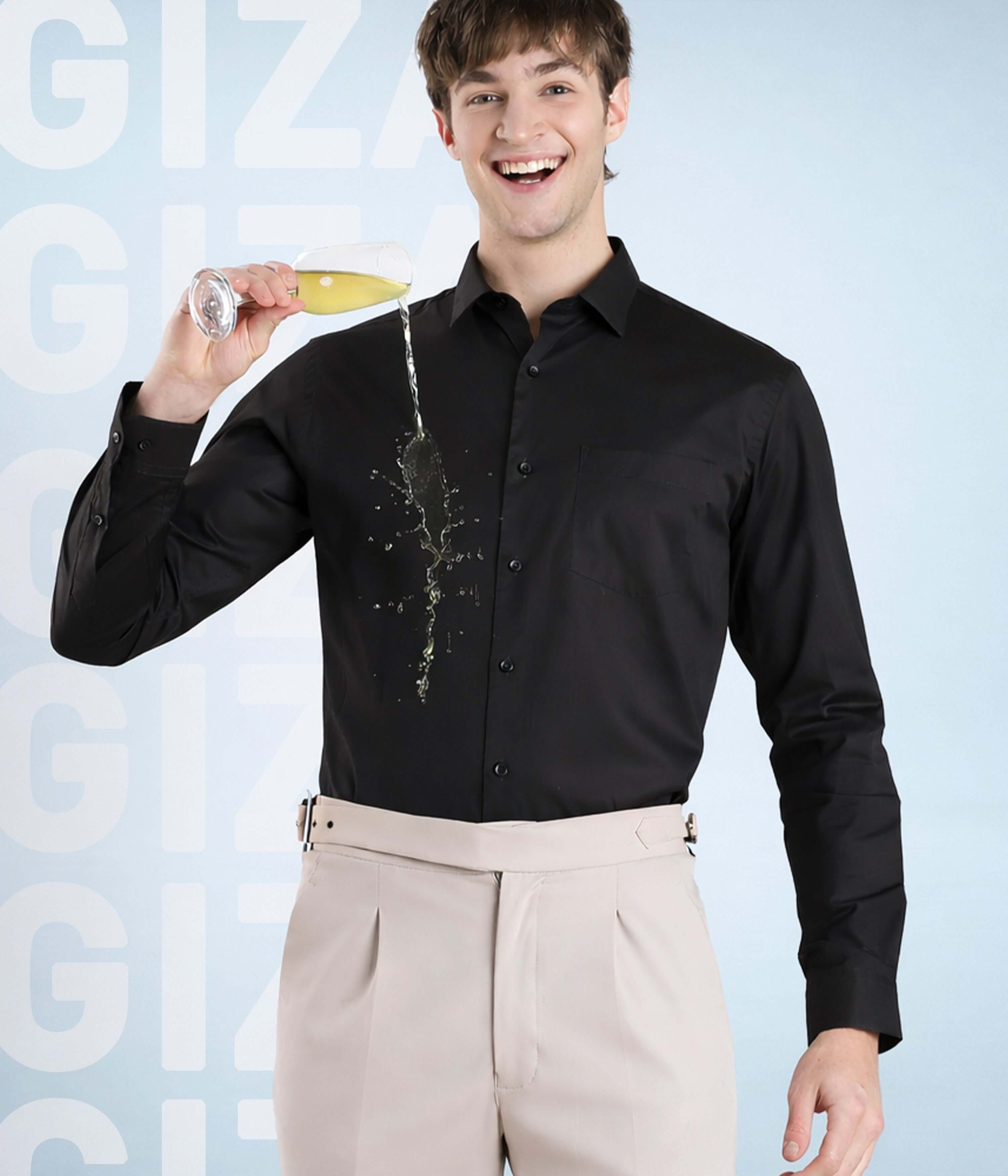 Olive Empire model wearing a black Giza cotton shirt, stylishly pouring a drink, showcasing premium quality.