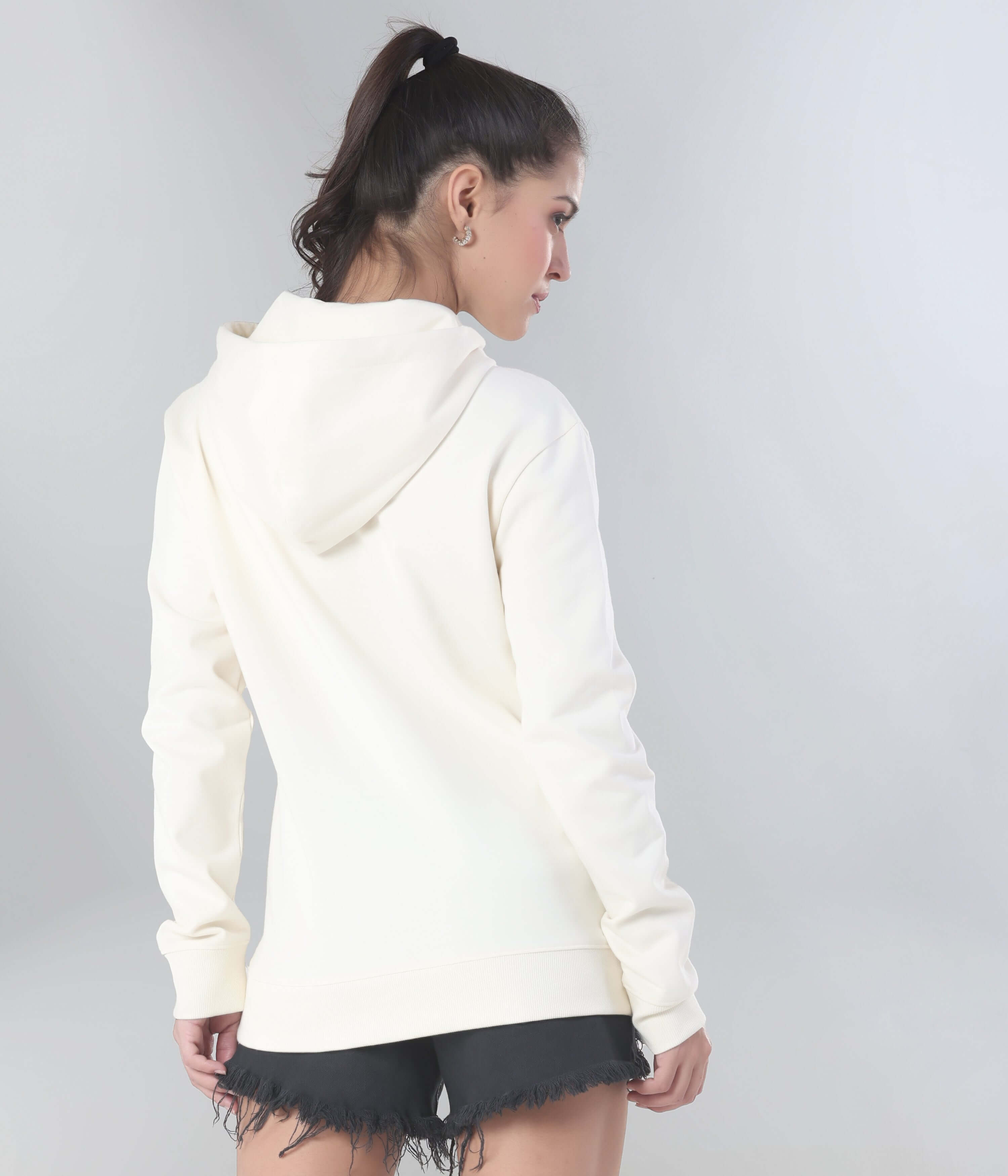 Woman in cream hooded sweatshirt, showcasing comfort and style for travel wear, featuring anti-stain and water-resistant properties.