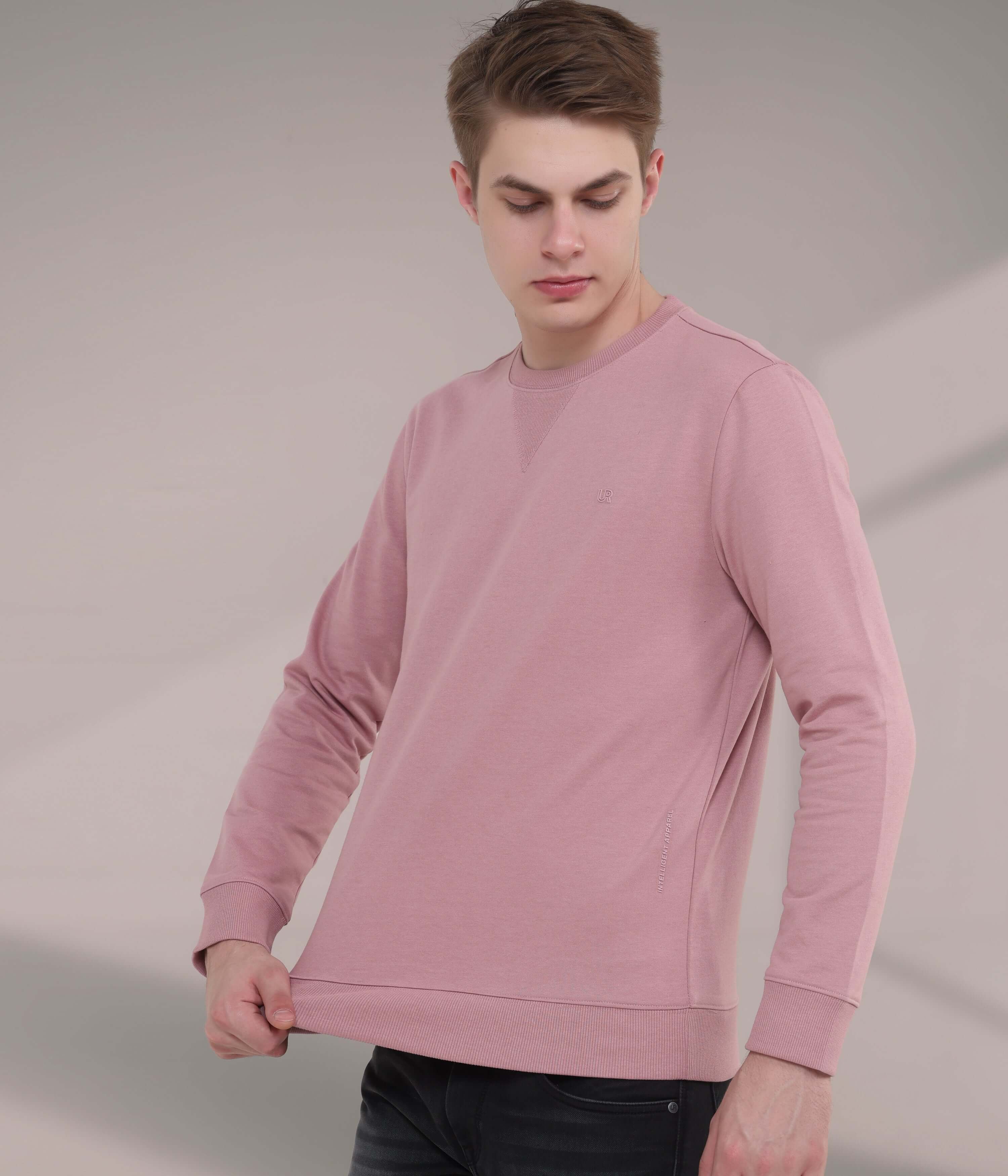 Young man wearing a pink sweatshirt, showcasing style and comfort, perfect for everyday wear and men's fashion.