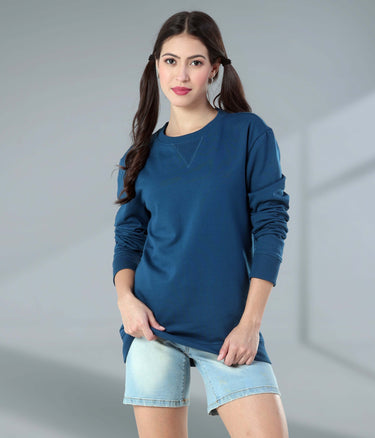 Stylish woman wearing a blue Turms Intelligent Sweatshirt and denim shorts, showcasing comfort and modern fashion.