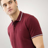 Man wearing maroon Turms anti-stain, anti-odor premium cotton polo T-shirt with tailored fit and white striped collar