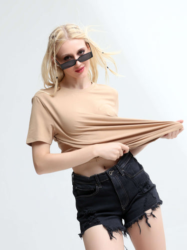 Woman wearing trendy, casual round-neck Camel Turms T-shirt with black denim shorts, showcasing stylish and comfortable casual wear.