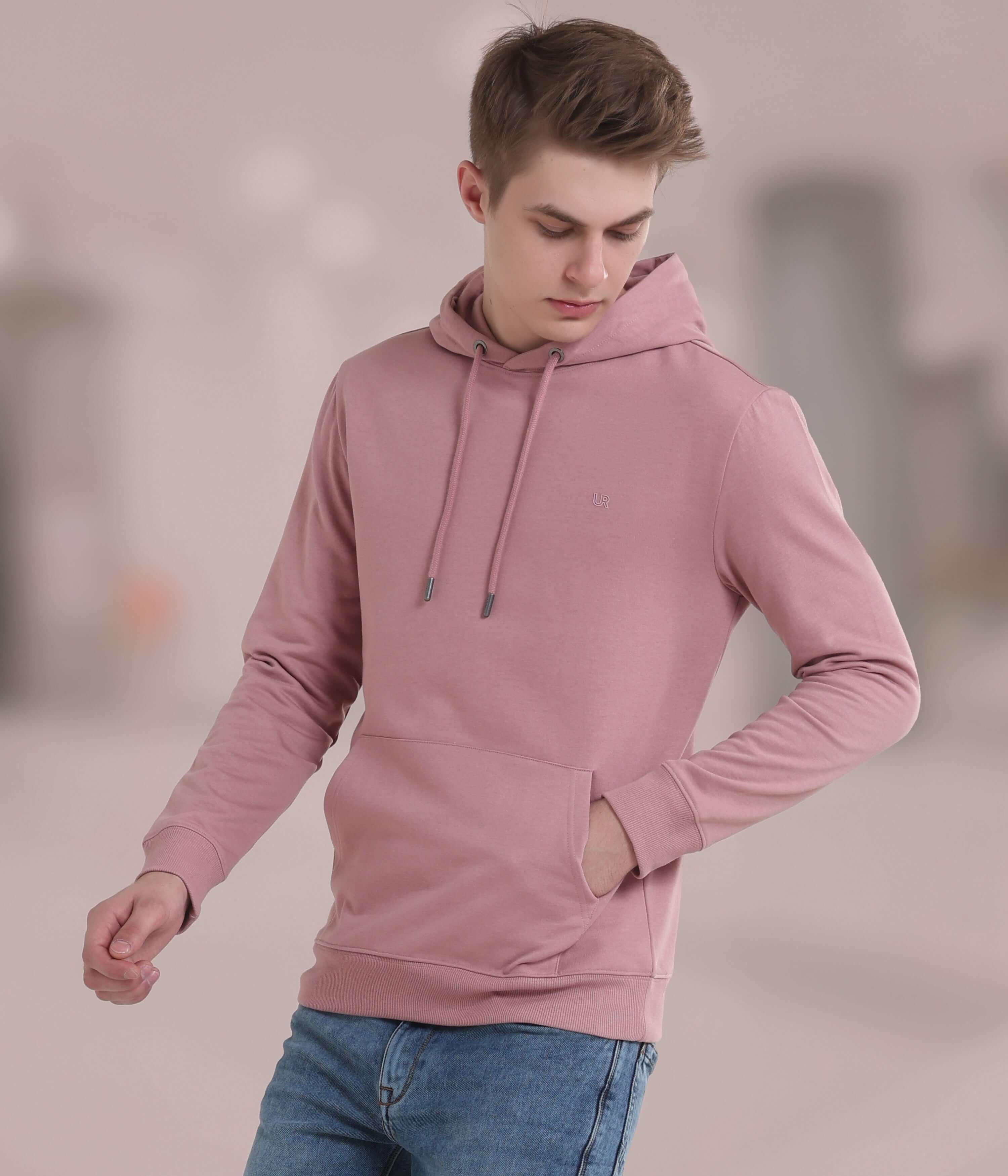 Model wearing a pink hooded sweatshirt, showcasing style and comfort in a breathable, durable fabric.