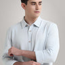 Man wearing a premium white knitted shirt with button-down collar, showcasing anti-stain and anti-odor features in menswear.