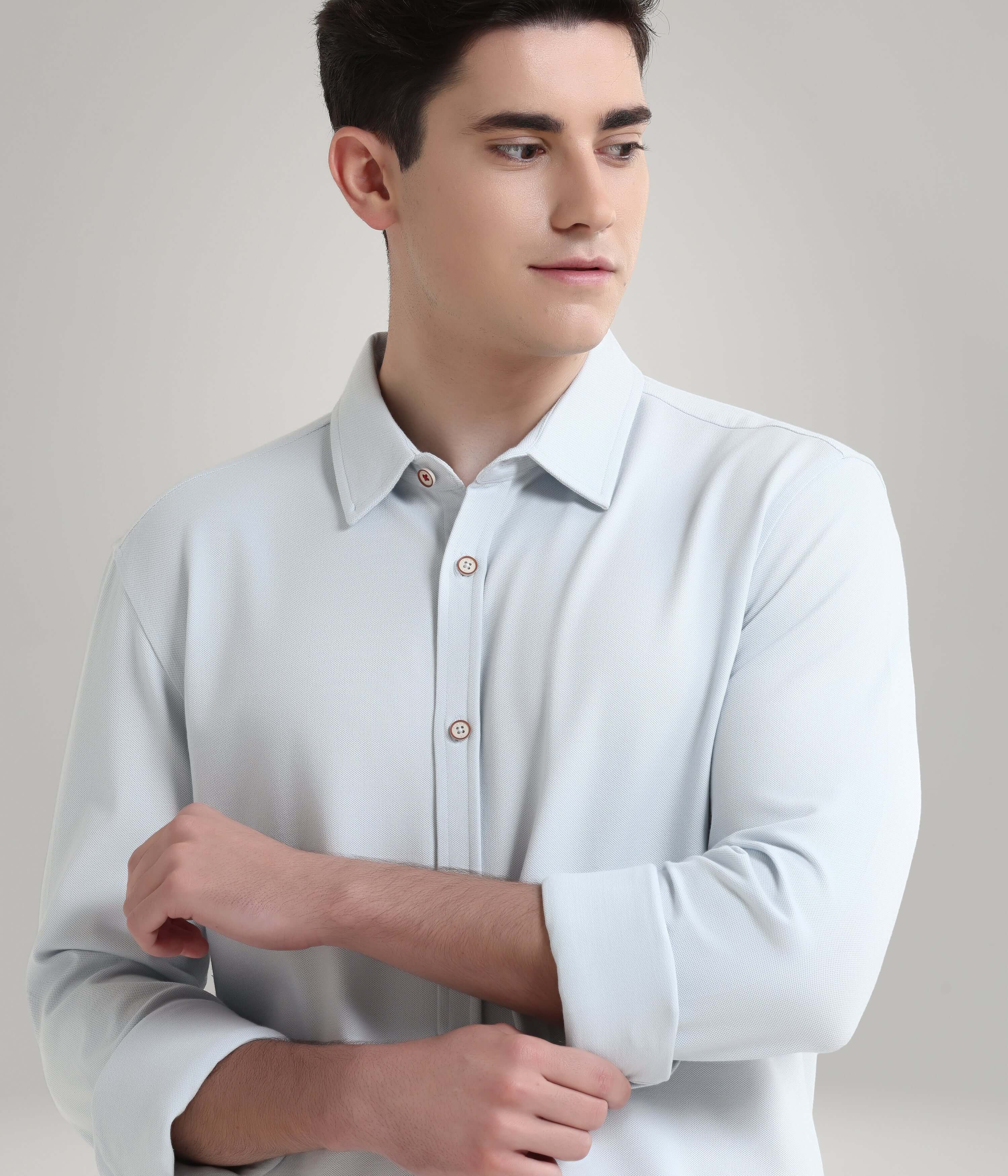 Man wearing a premium white knitted shirt with button-down collar, showcasing anti-stain and anti-odor features in menswear.