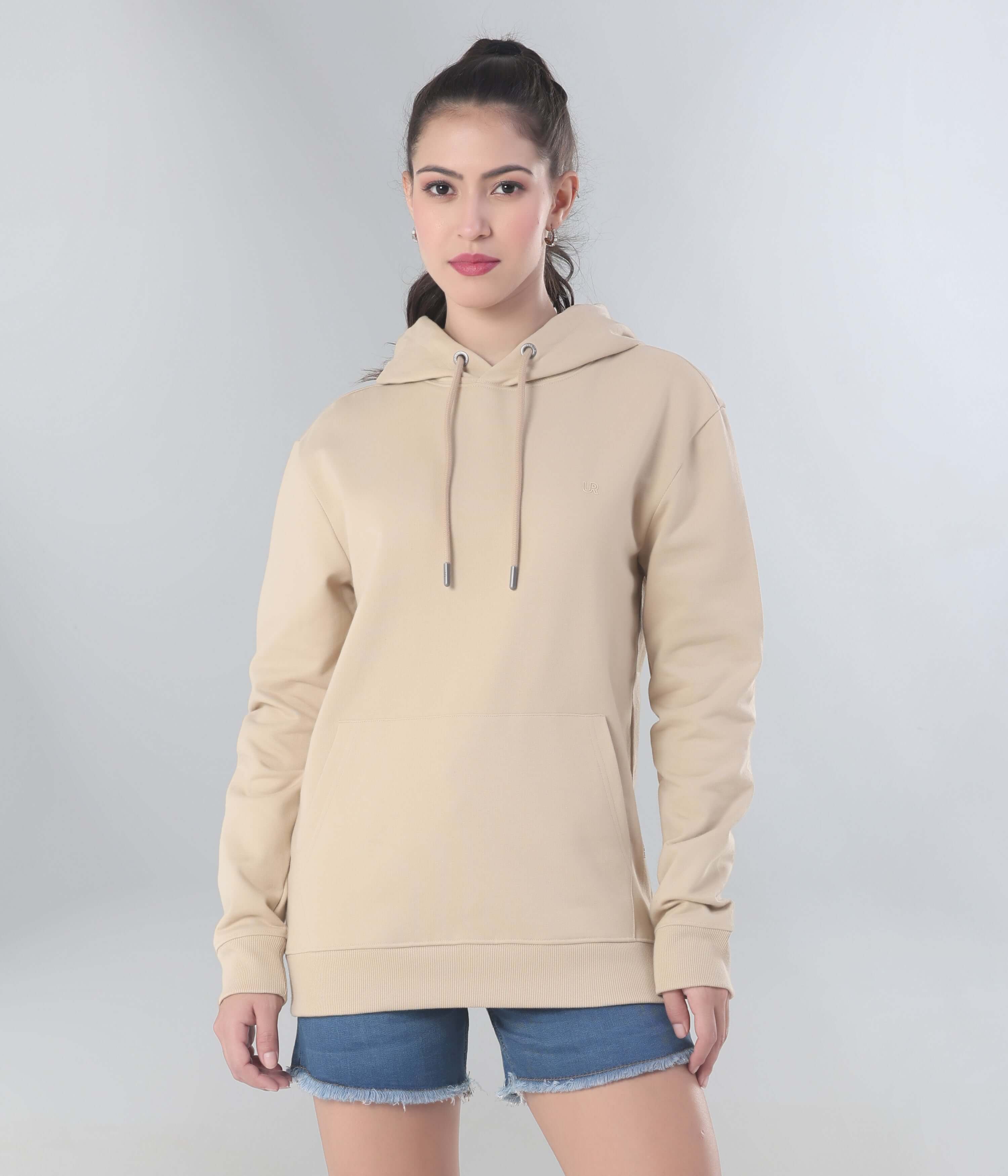 Woman wearing a beige Turms Intelligent Hooded Sweatshirt, showcasing style, comfort, and functionality for travel wear.