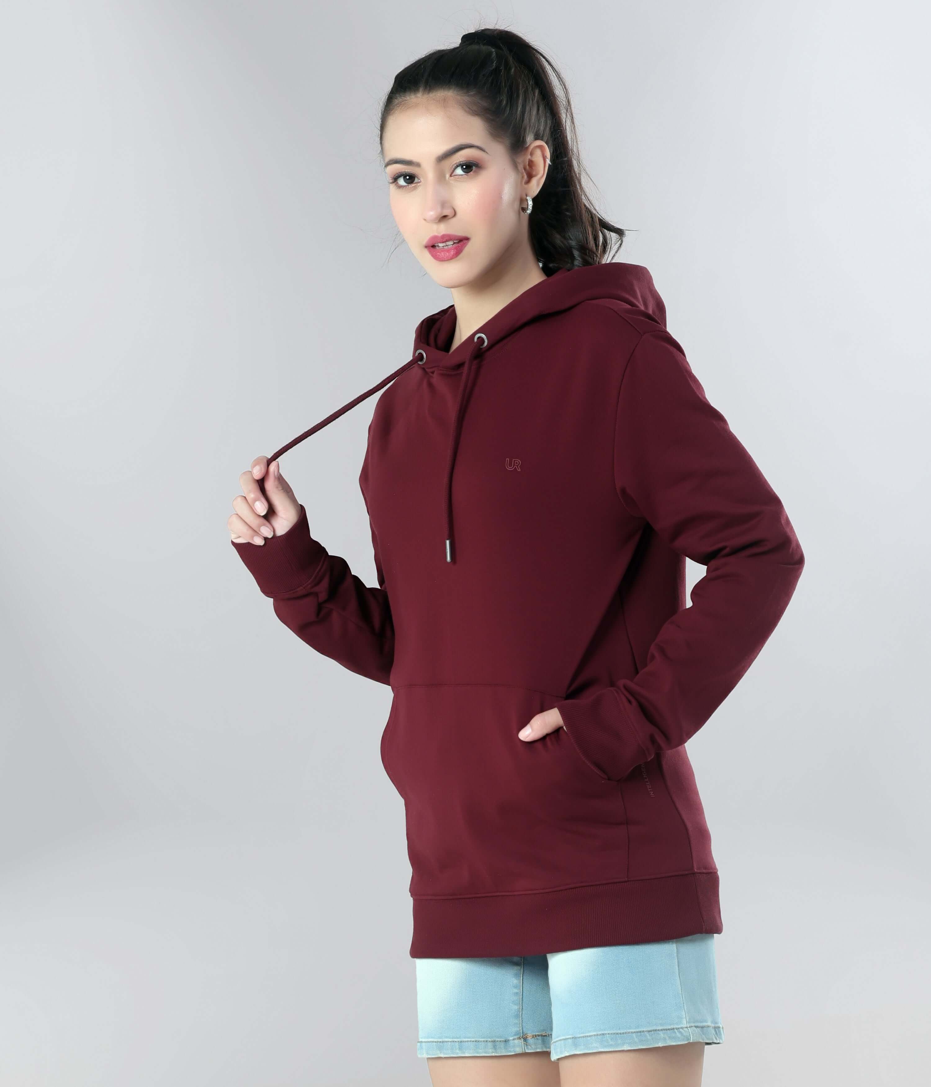 Woman in a maroon hooded sweatshirt showcasing style and comfort, ideal for travel wear and everyday use.