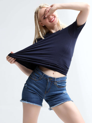 Woman wearing blue Turms round-neck T-shirt and denim shorts, demonstrating the stretchable and comfortable fabric.