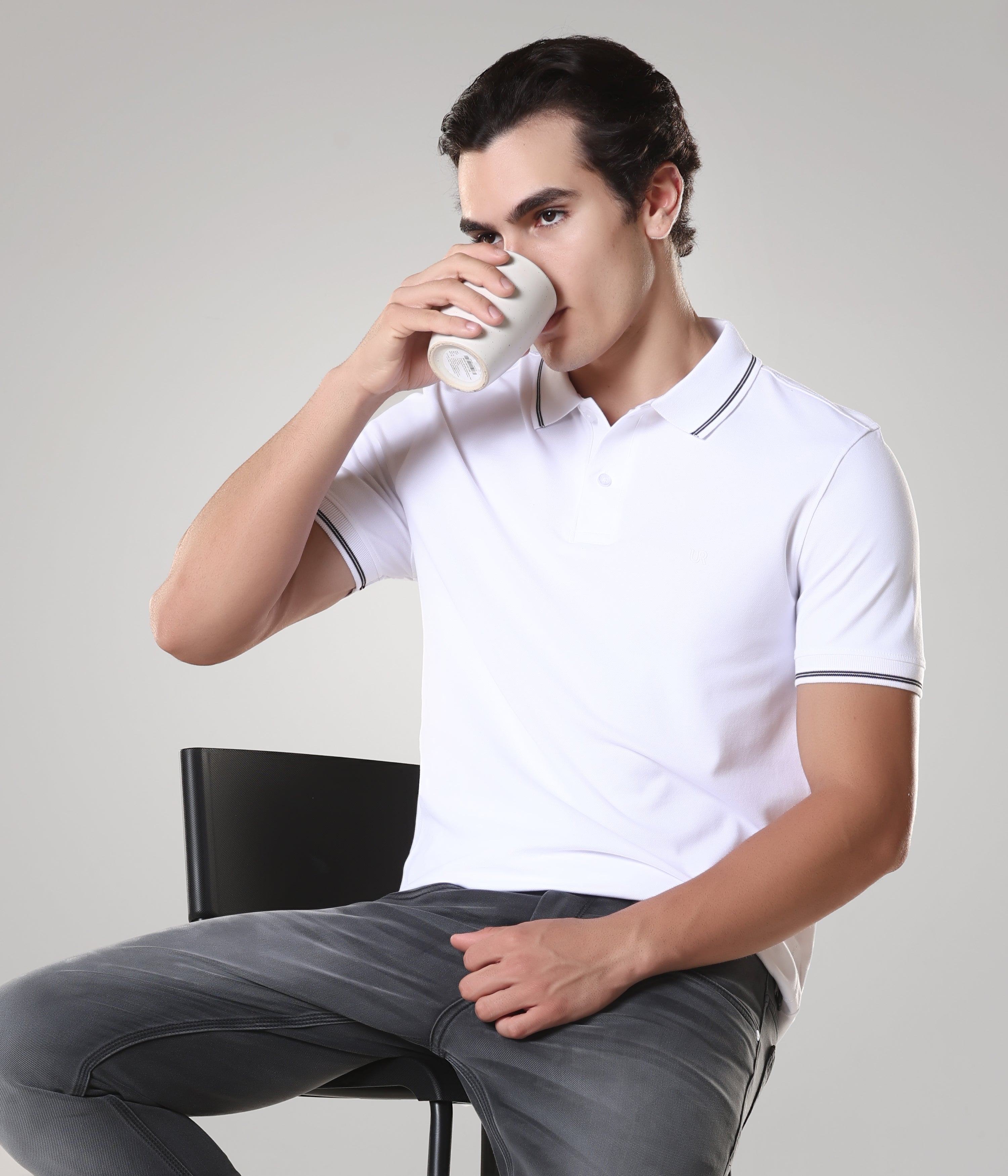 Man wearing white Turms Polo T-shirt drinking coffee, anti-stain, anti-odor, premium cotton, tailored fit.