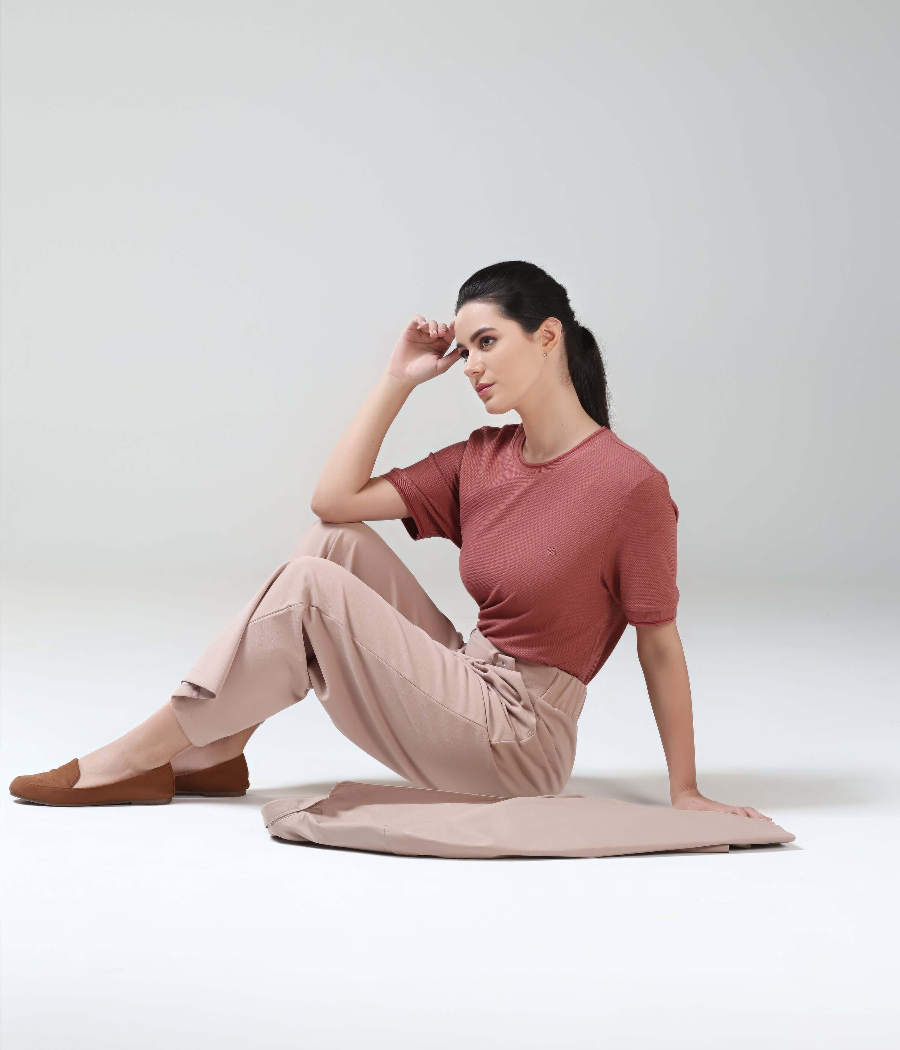 Woman wearing Vivid Brick Turms T-shirt with COOLTECH, honeycomb fabric, anti-odour, intelligent apparel sitting on floor in tailored fit and crew neckline.