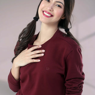 Woman smiling in a burgundy Turms Intelligent Sweatshirt, showcasing comfort and style for everyday wear.