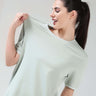 Woman wearing a Serene Light Green coolant round-neck Turms T-shirt with COOLTECH technology, showcasing tailored fit and honeycomb fabric, anti-odour.