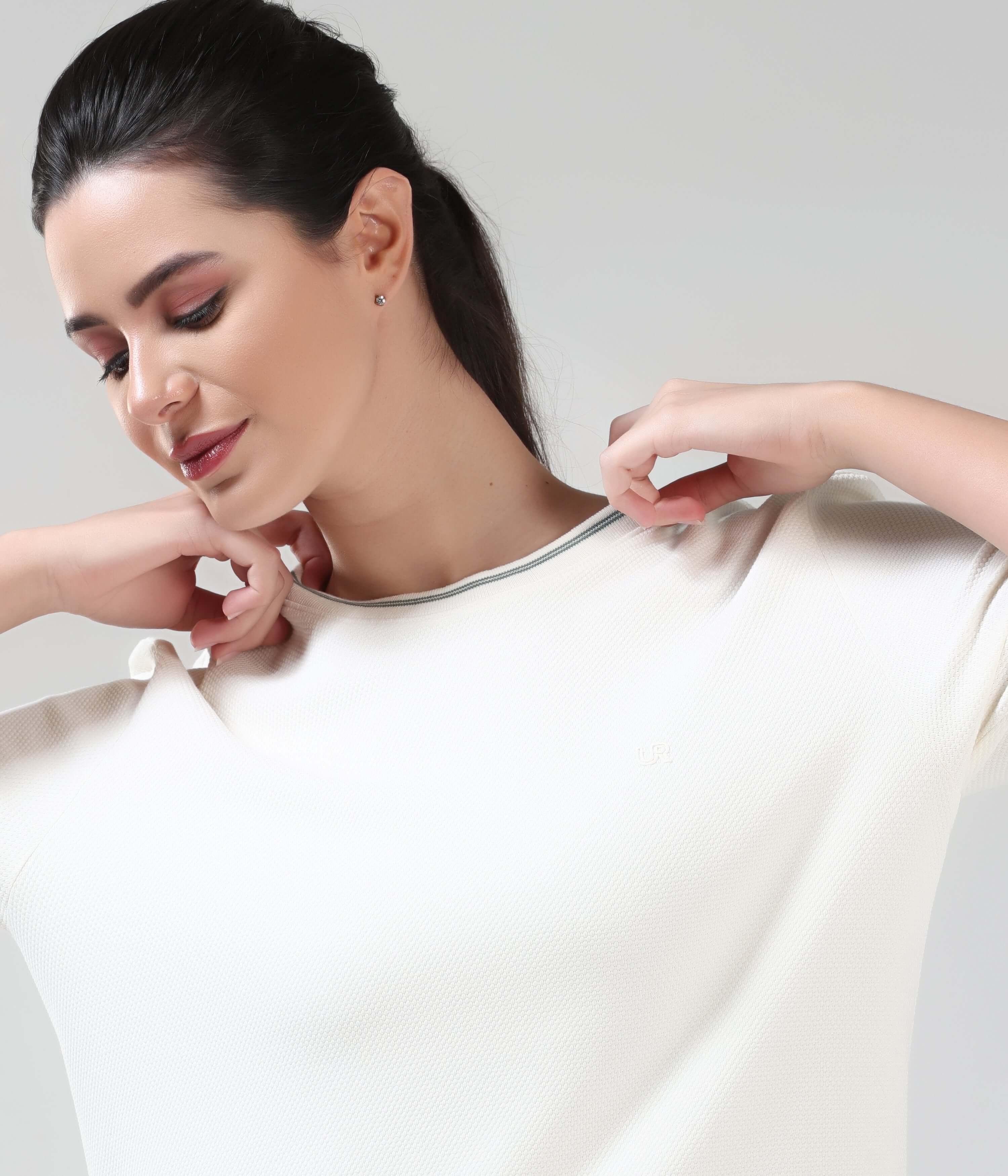 Woman wearing Pearl Off White COOLTECH T-shirt by Turms, featuring honeycomb fabric and anti-odour properties. New Colour, Intelligent Apparel.