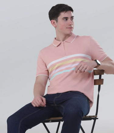 Man seated wearing a pink striped polo shirt, showcasing stylish casual attire perfect for everyday wear.