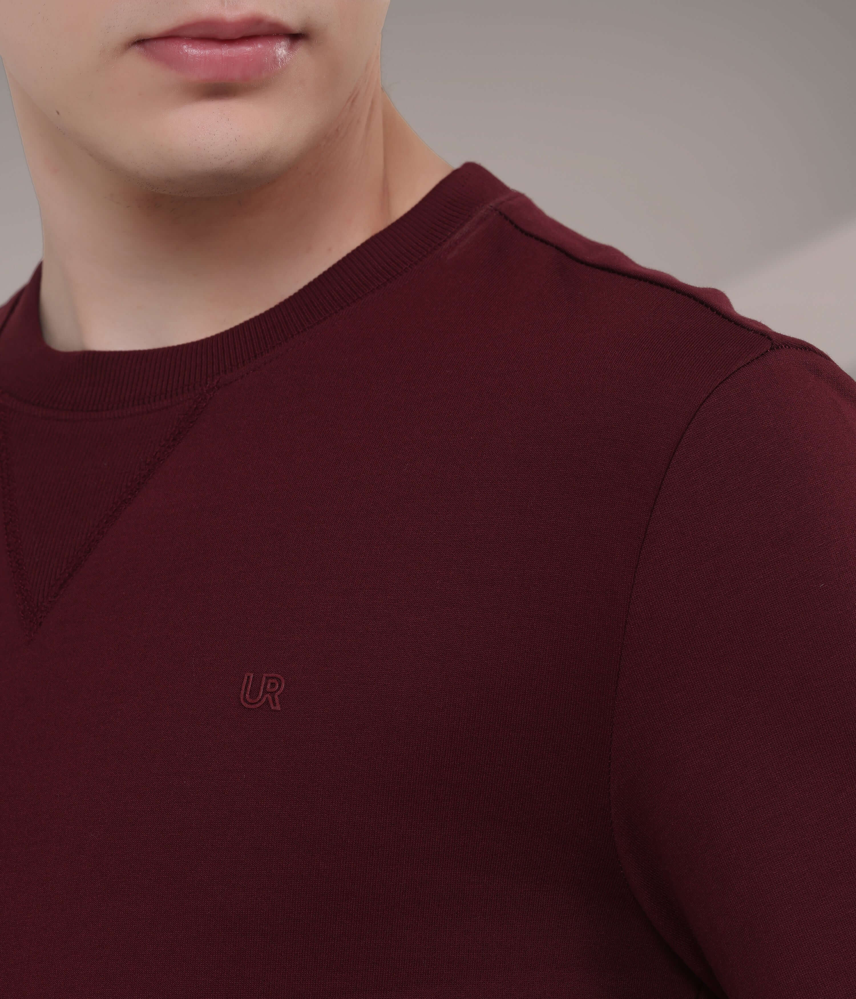 Close-up of a man wearing a burgundy Turms Intelligent Sweatshirt, featuring a V-notch neckline and soft cotton-blend fabric.