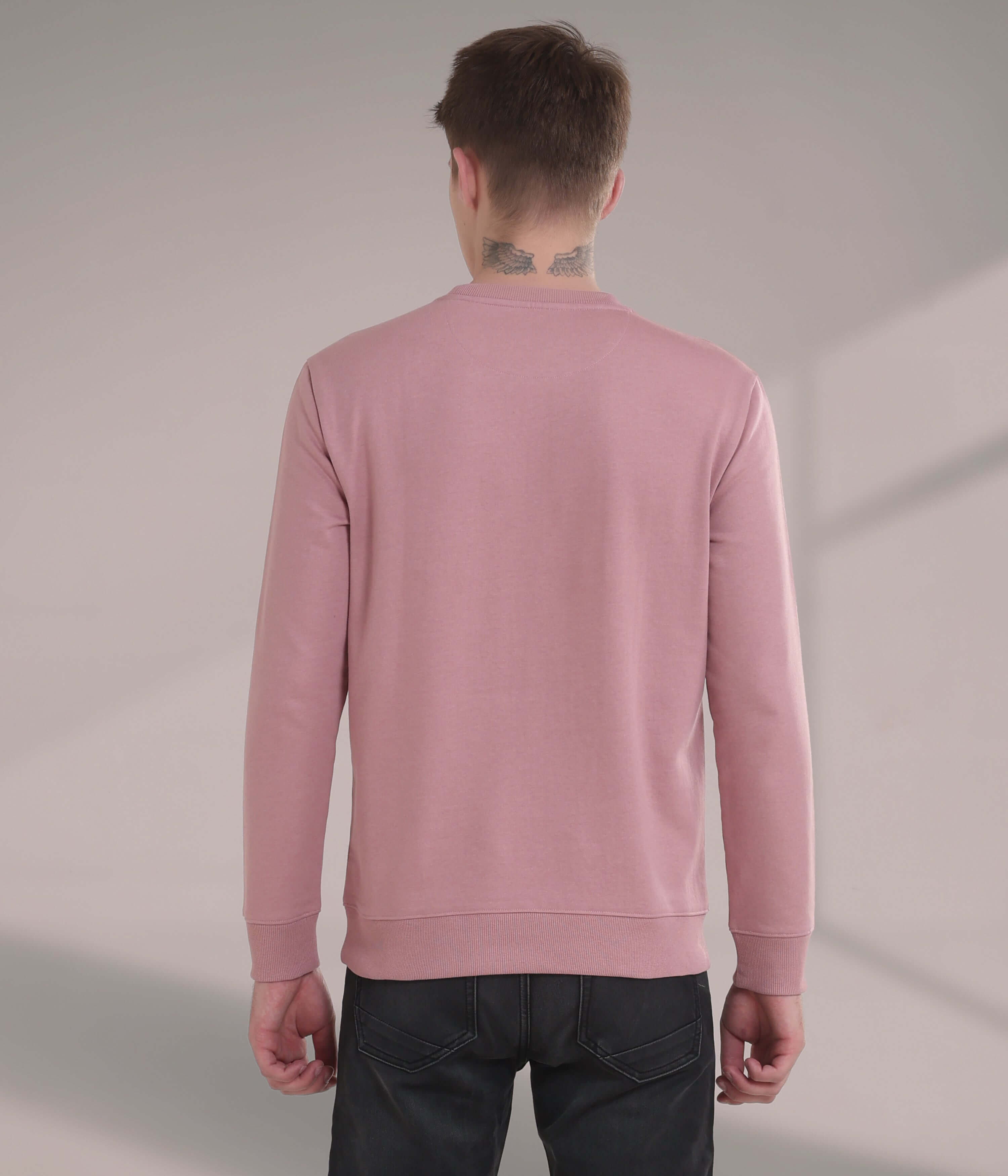 Back view of a man wearing a pink Turms Intelligent Sweatshirt, showcasing its stylish and comfortable design.