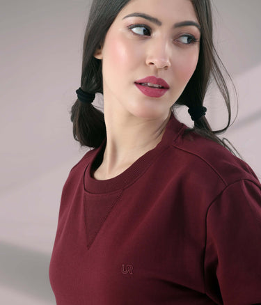 Woman wearing a burgundy Turms Intelligent Sweatshirt with V-notch neckline, showcasing style and comfort.