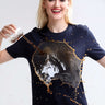 Woman wearing a stain-proof and odor-resistant round-neck Turms T-shirt while spilling drink, demonstrating stain-repellent quality