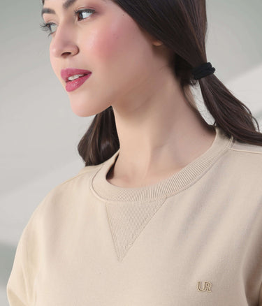Woman wearing a beige Turms Intelligent Sweatshirt with V-notch neckline, showcasing style and comfort. Best women's hoodie featured.