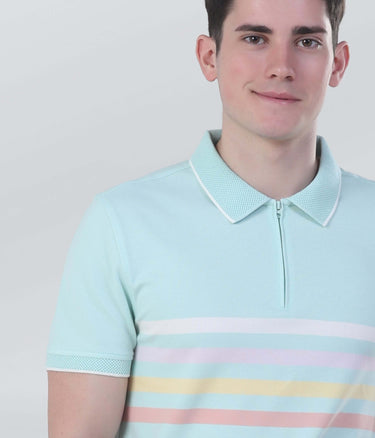 Model wearing a light blue striped zipped polo shirt, showcasing sustainable cotton fabric and modern style.