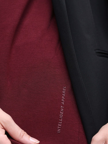 Close-up of cranberry-colored Turms T-shirt with "Intelligent Apparel" text, showcasing stain and odor-resistant fabric.