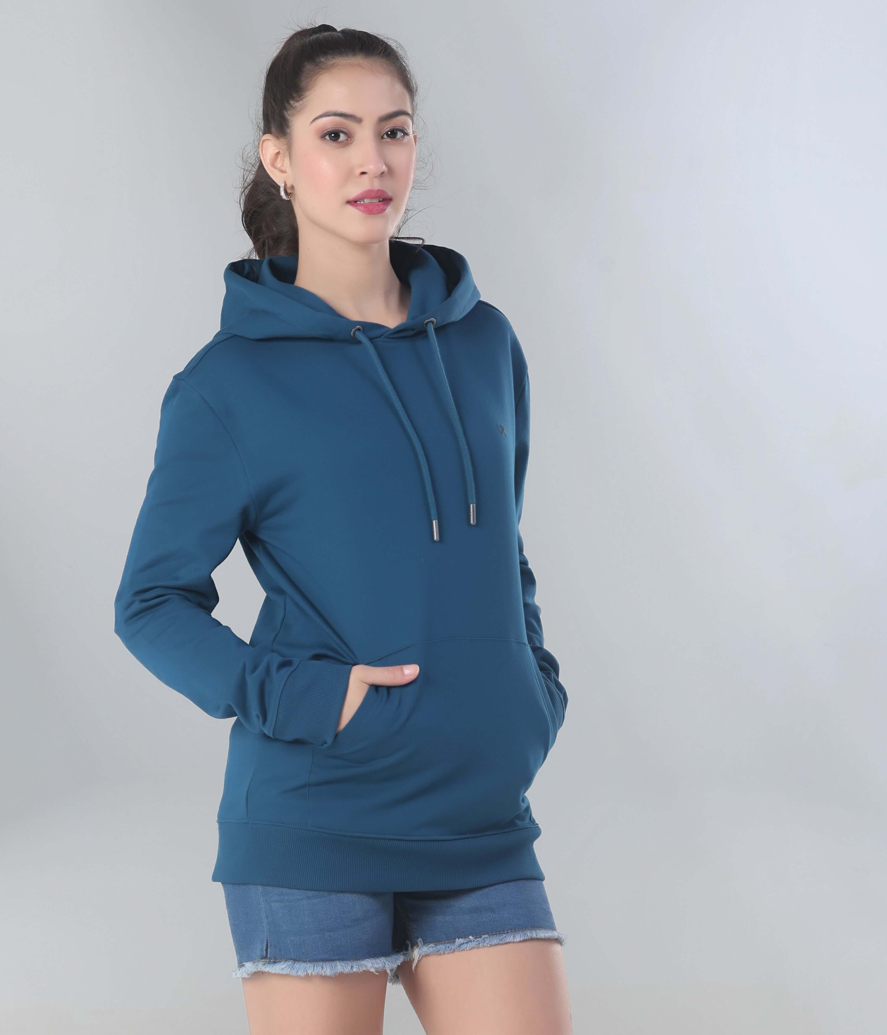 Stylish woman wearing a blue hooded sweatshirt, perfect for travel and everyday comfort. Features anti-stain and water-resistant fabric.