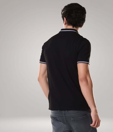 Man wearing black Turms Polo T-shirt with anti-stain and anti-odor features, premium cotton blend, tailored fit, and polo collar.