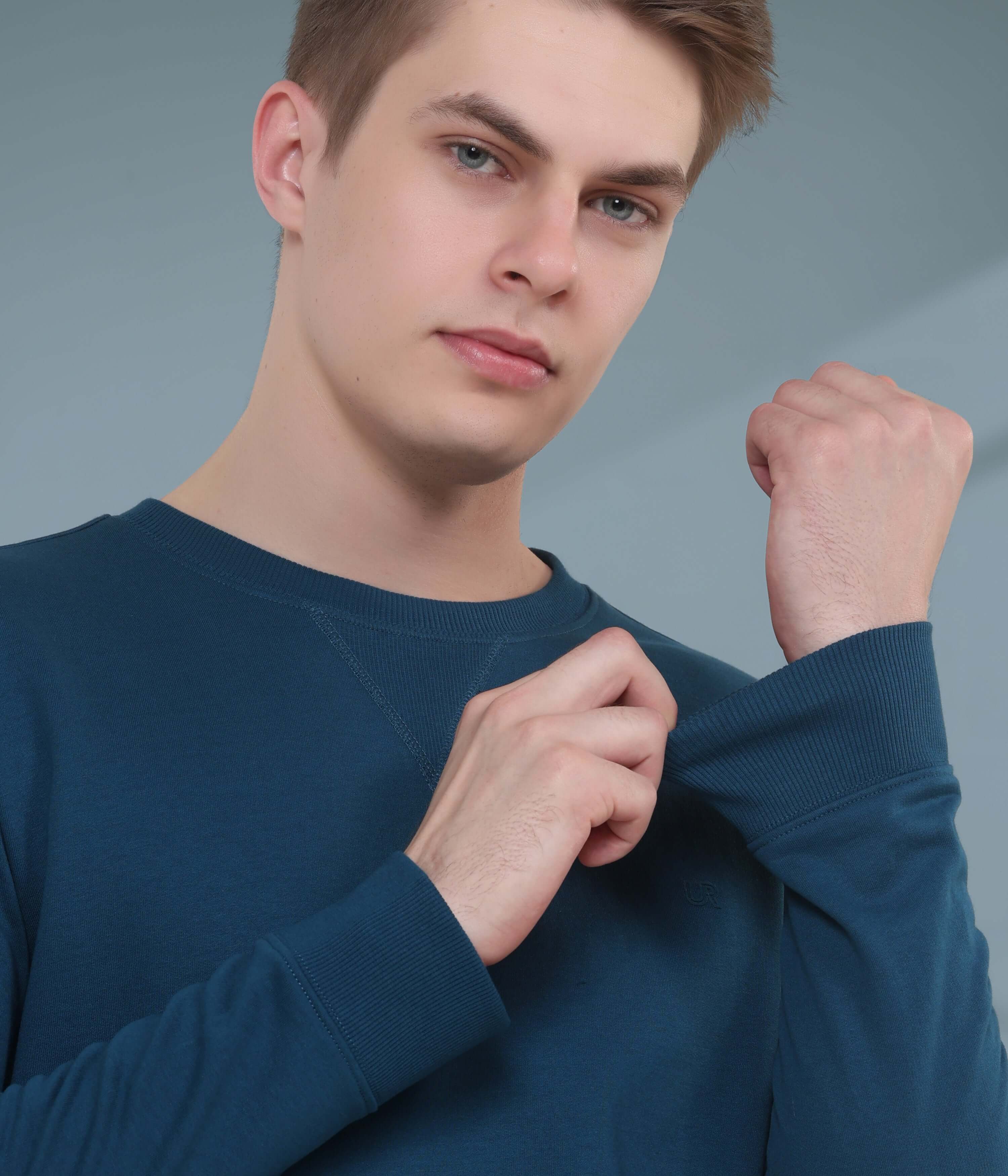 Man showcasing the comfortable blue Turms Intelligent Sweatshirt, designed for style and durability in everyday wear.