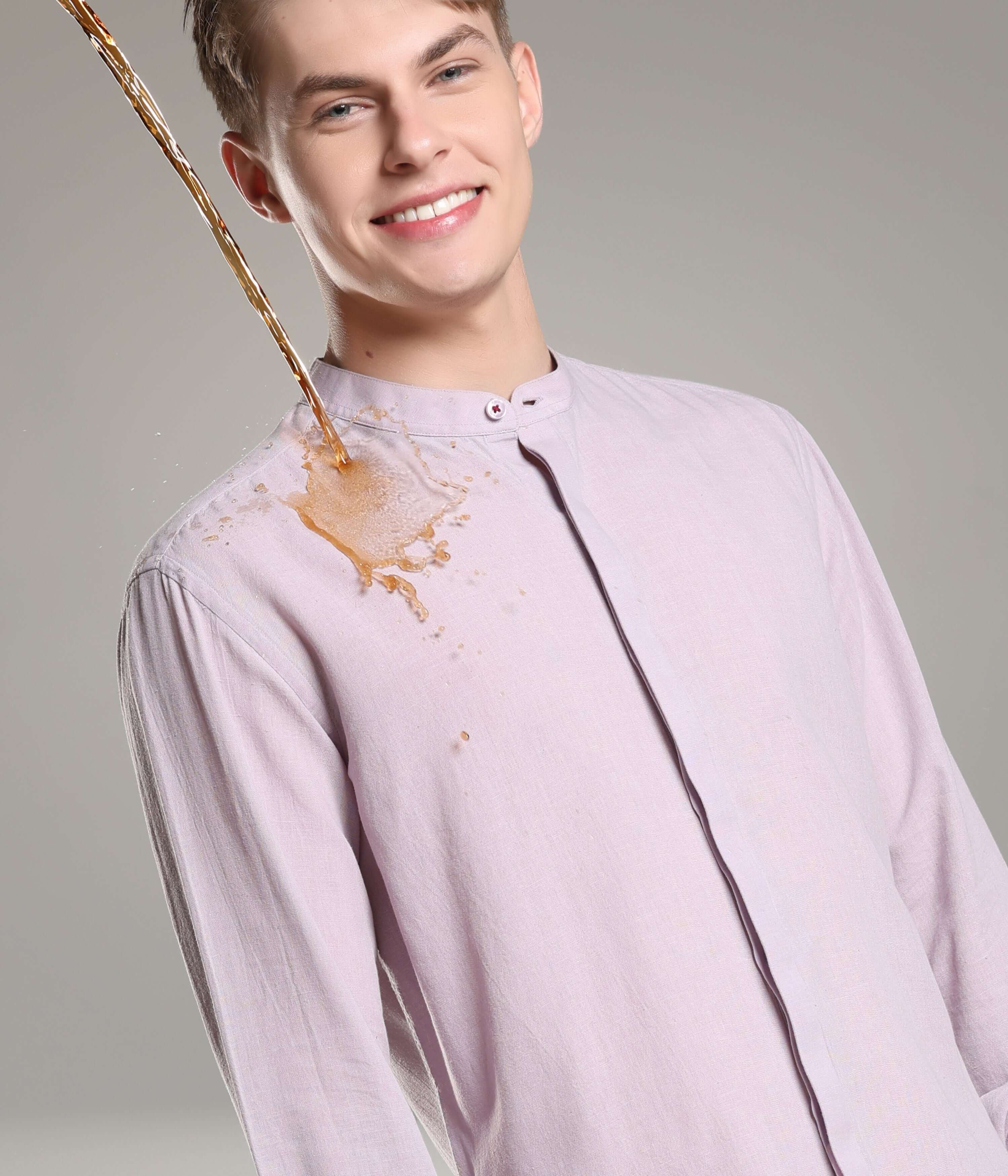 Man wearing Bergamot Lavender Cotton/Linen Turms shirt demonstrates antistain technology as liquid spills off without staining.