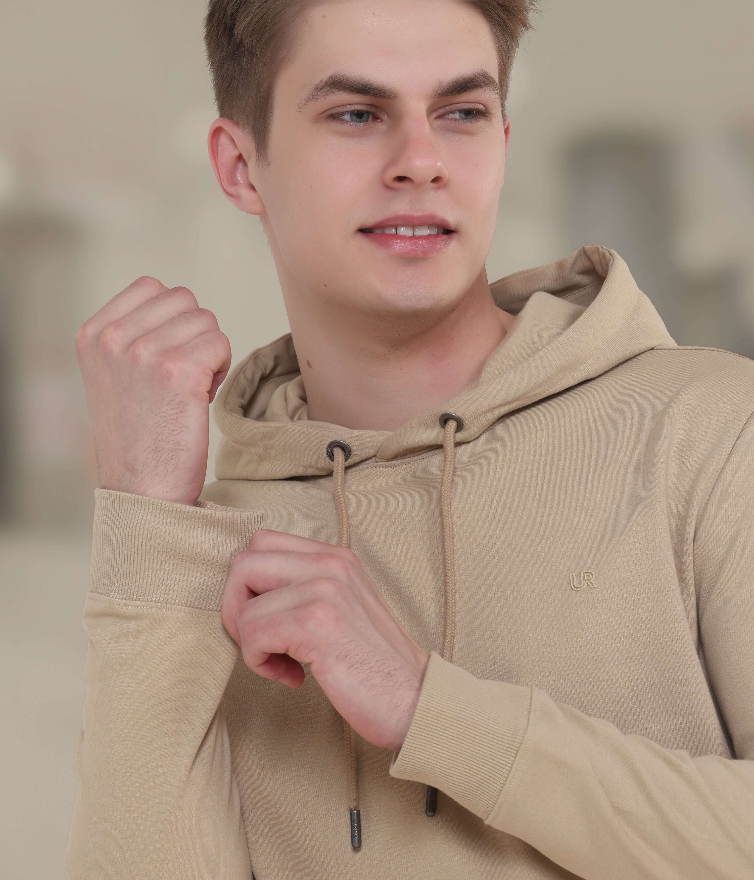 Young man in a camel-colored hooded sweatshirt showcasing style and comfort, ideal for everyday wear.