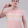 Man in a pink striped polo shirt pouring a drink, showcasing an anti-stain and breathable design.