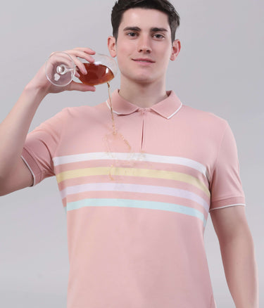 Man in a pink striped polo shirt pouring a drink, showcasing an anti-stain and breathable design.