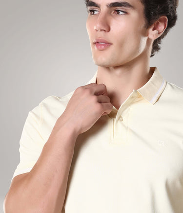 Model wearing a yellow premium cotton Turms polo T-shirt with tailored fit, featuring anti-stain and anti-odour technology.