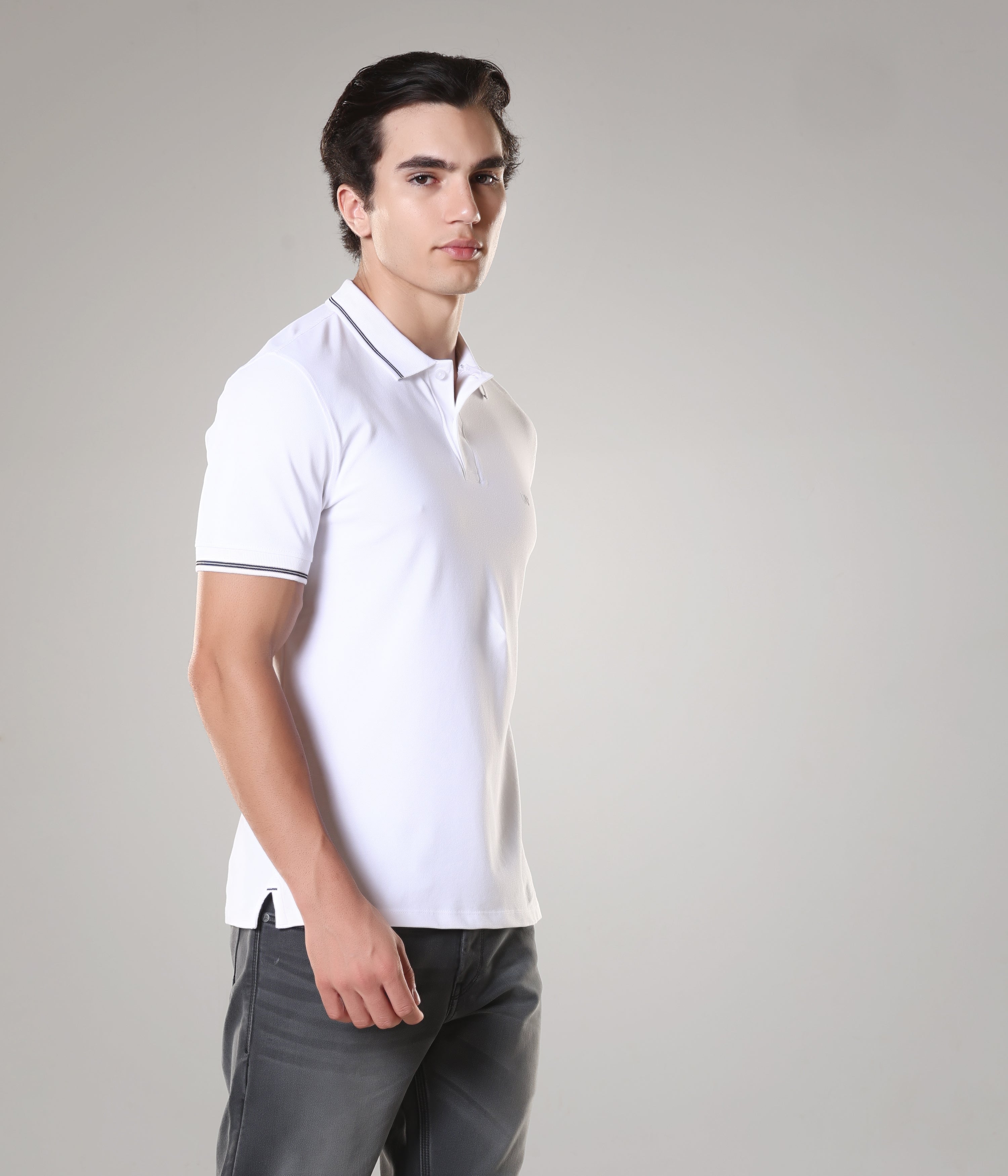 Man wearing a tailored fit white Turms Polo T-shirt made of premium cotton and spandex with anti-stain, anti-odor, and anti-microbial features