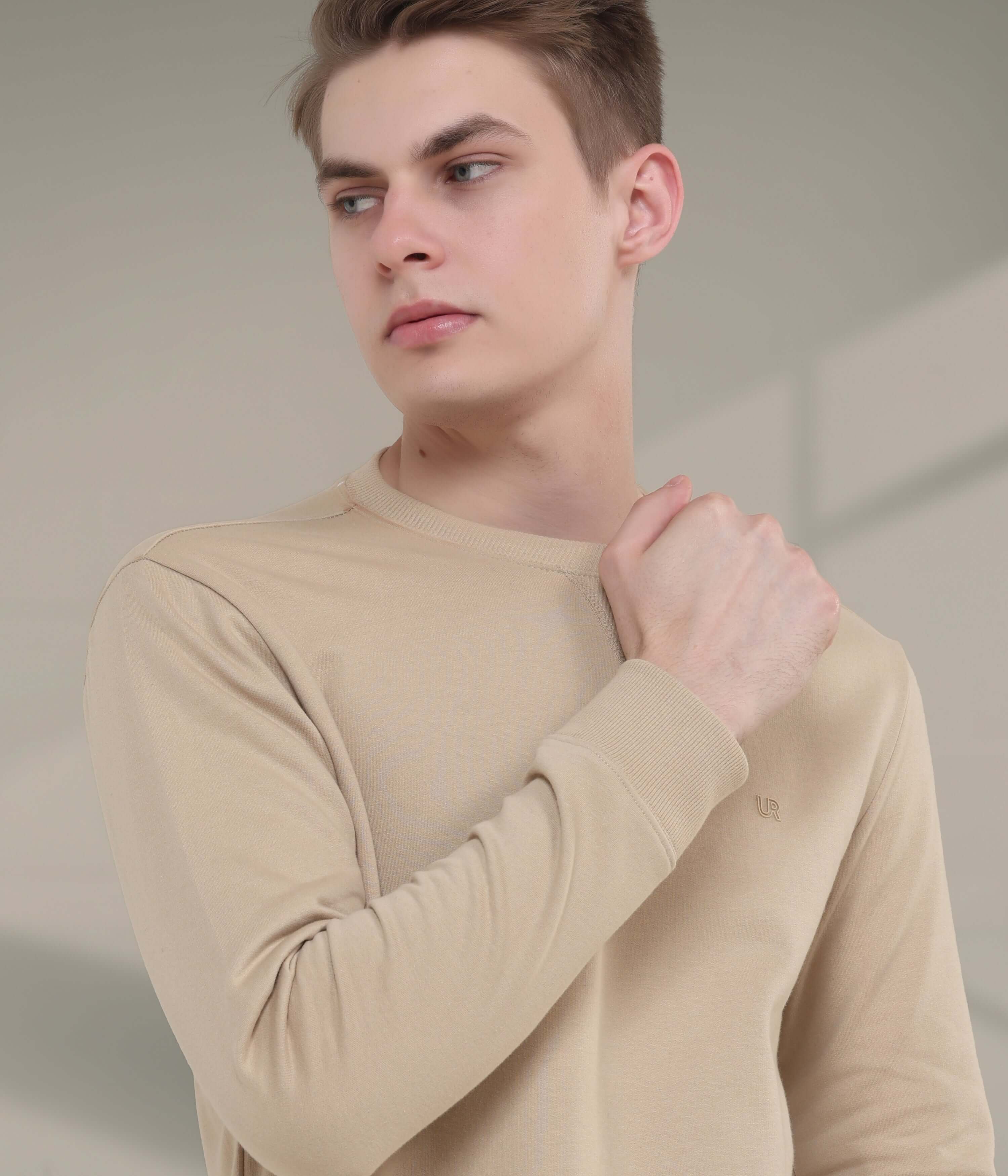 Model wearing beige Turms Intelligent Sweatshirt, showcasing style, comfort, and durability for everyday wear.